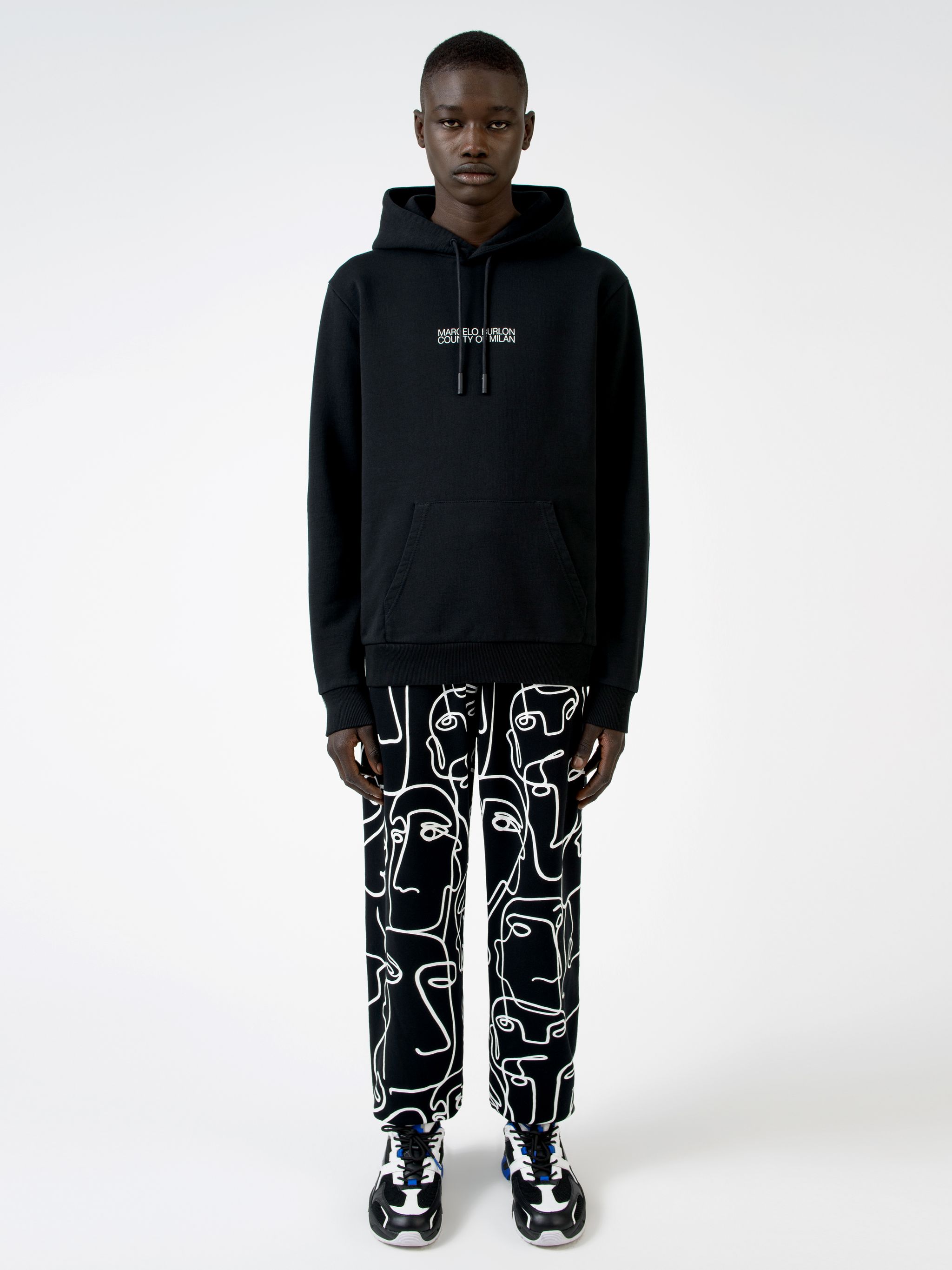 Black cotton logo print hoodie from MARCELO BURLON COUNTY OF MILAN featuring drawstring hood, logo print to the front, long sleeves, abstract pattern print, kangaroo pocket and loose fit.