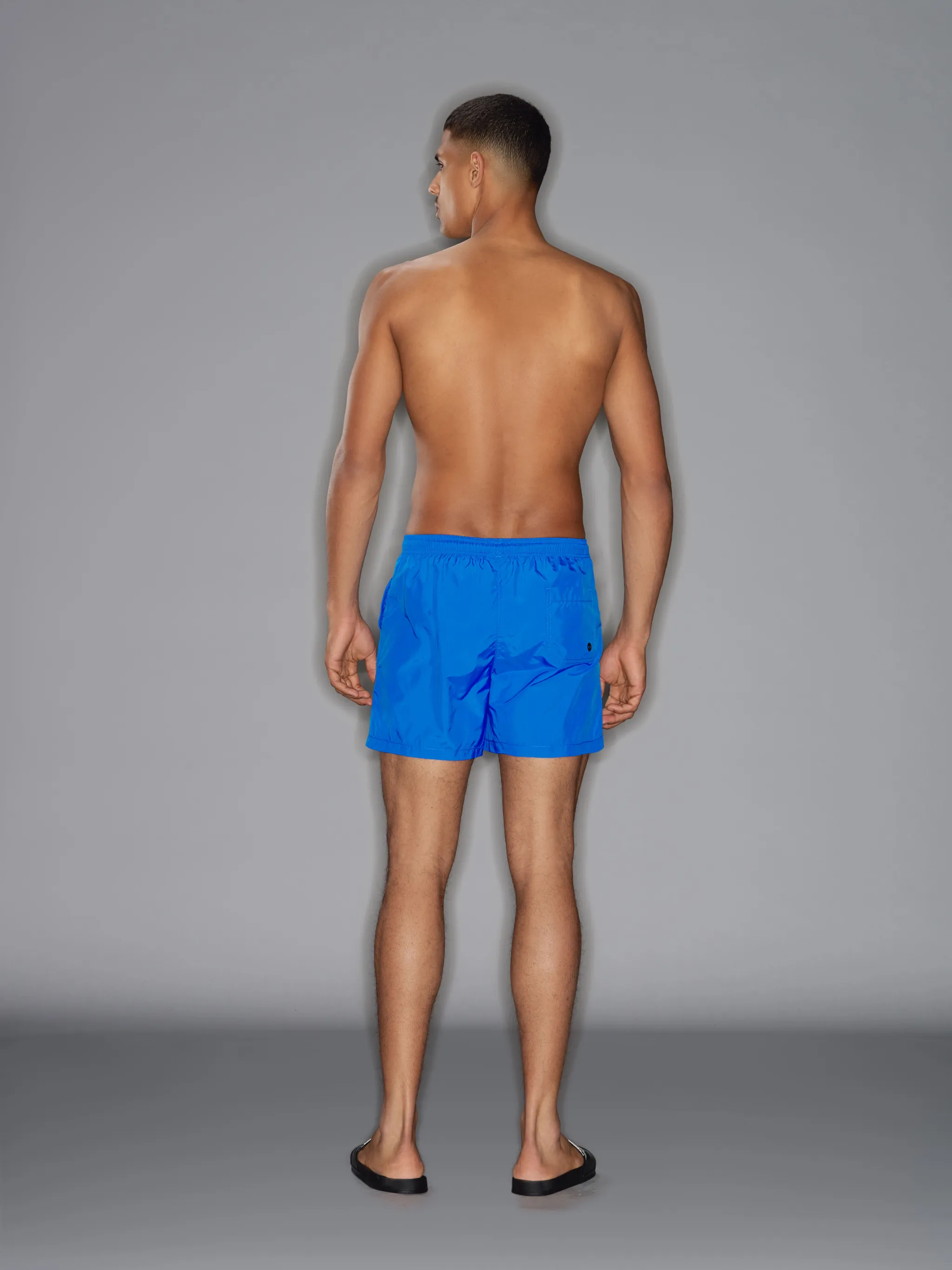 Blue drawstring swim shorts from Marcelo Burlon County of Milan featuring drawstring fastening waist, logo patch to the rear, two side slit pockets, rear patch pocket and straight hem. Be mindful to try on swimwear over your own garments..