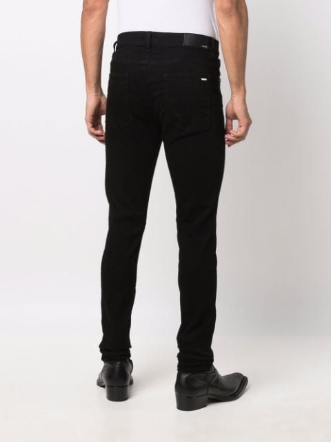 AMIRI black logo-plaque skinny jeans for men | XMD002 at Farfetch.com