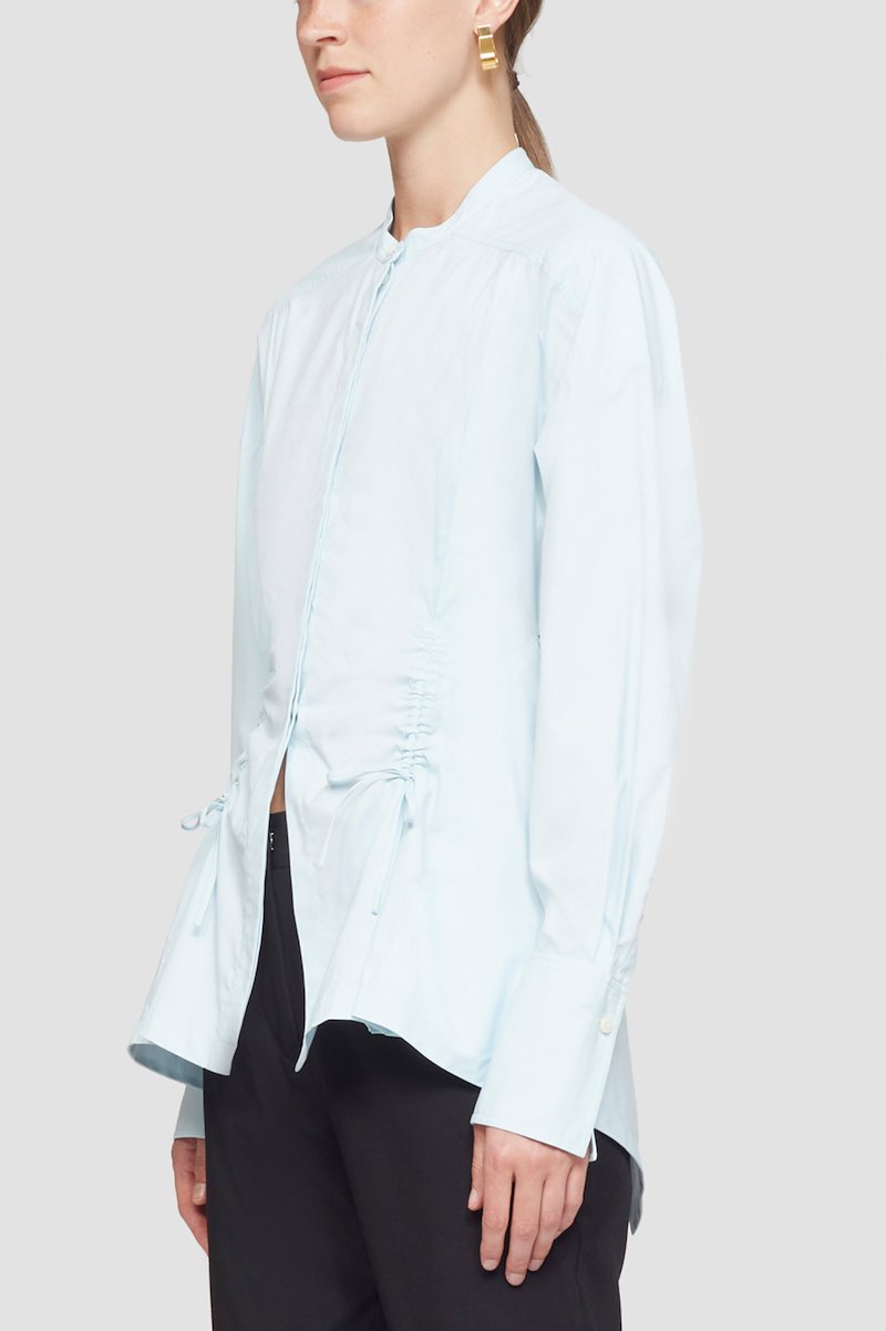 Ruched Tie Front Shirt with Open Back-blue #0 Ruched Tie Front Shirt with Open Back, draped peplum shirt from 3.1 PHILLIP LIM featuring ice blue, draped panel detail, cut-out detailing, lace-up detailing, band collar, concealed front fastening, long sleeves, buttoned cuffs and peplum hem.- 4