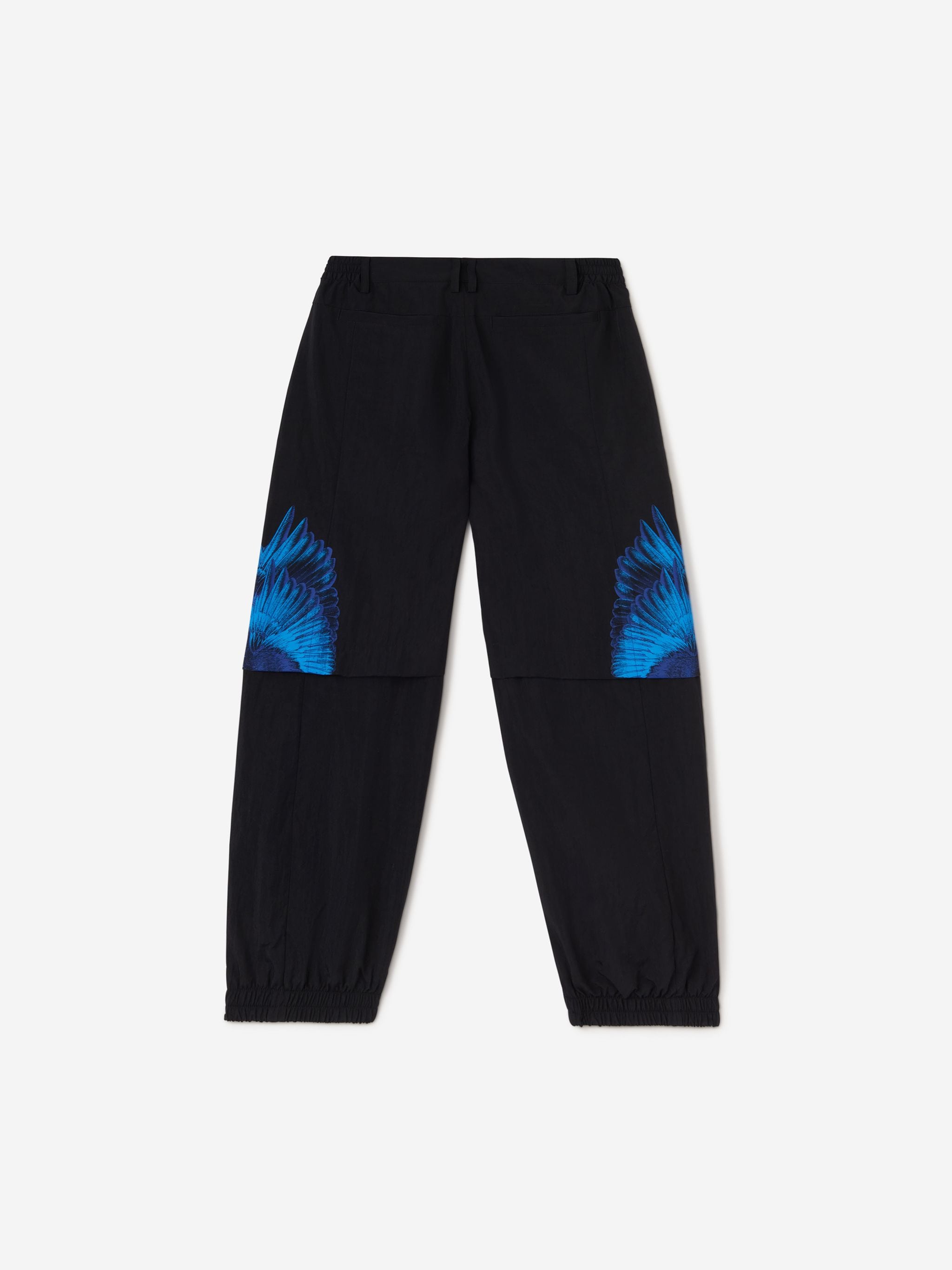 Black/blue x FILA feather print trousers from Marcelo Burlon County of Milan featuring feather print, logo patch to the side, slip pockets to the sides, elasticated waistband, front button and zip fastening and elasticated ankles.