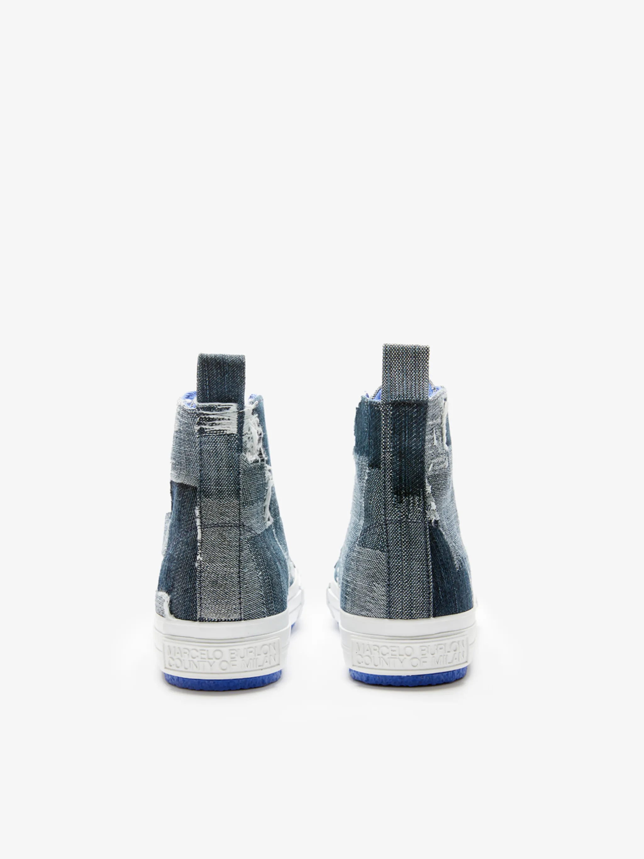 patchwork denim high-top sneakers from Marcelo Burlon County of Milan featuring blue, indigo blue, chalk white, cotton, patchwork design, round toe, contrasting toecap, front lace-up fastening, pull-tab at the heel and flat rubber sole.