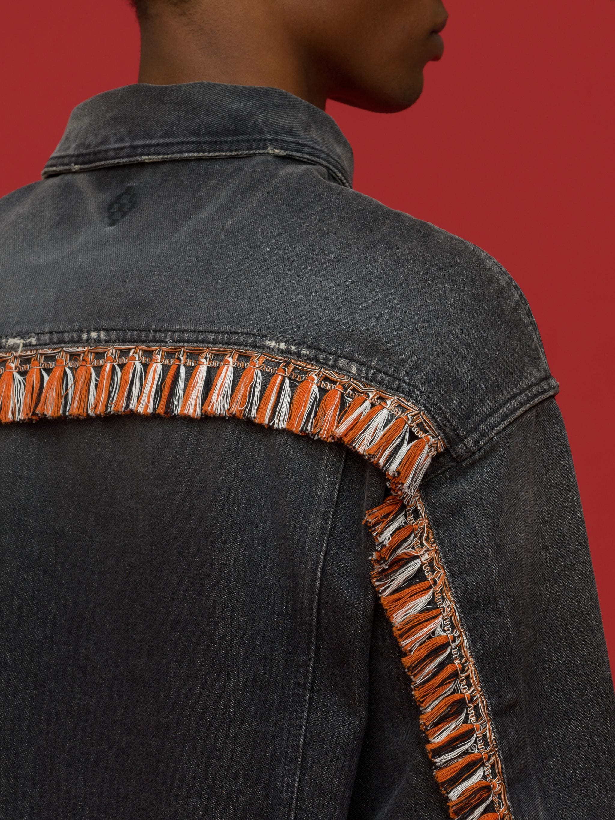 tassel-detail denim jacket from Marcelo Burlon County of Milan featuring black, orange, tassel detail, logo patch to the rear, classic collar, front button fastening, two chest patch pockets, two side slit pockets, long sleeves and straight hem.