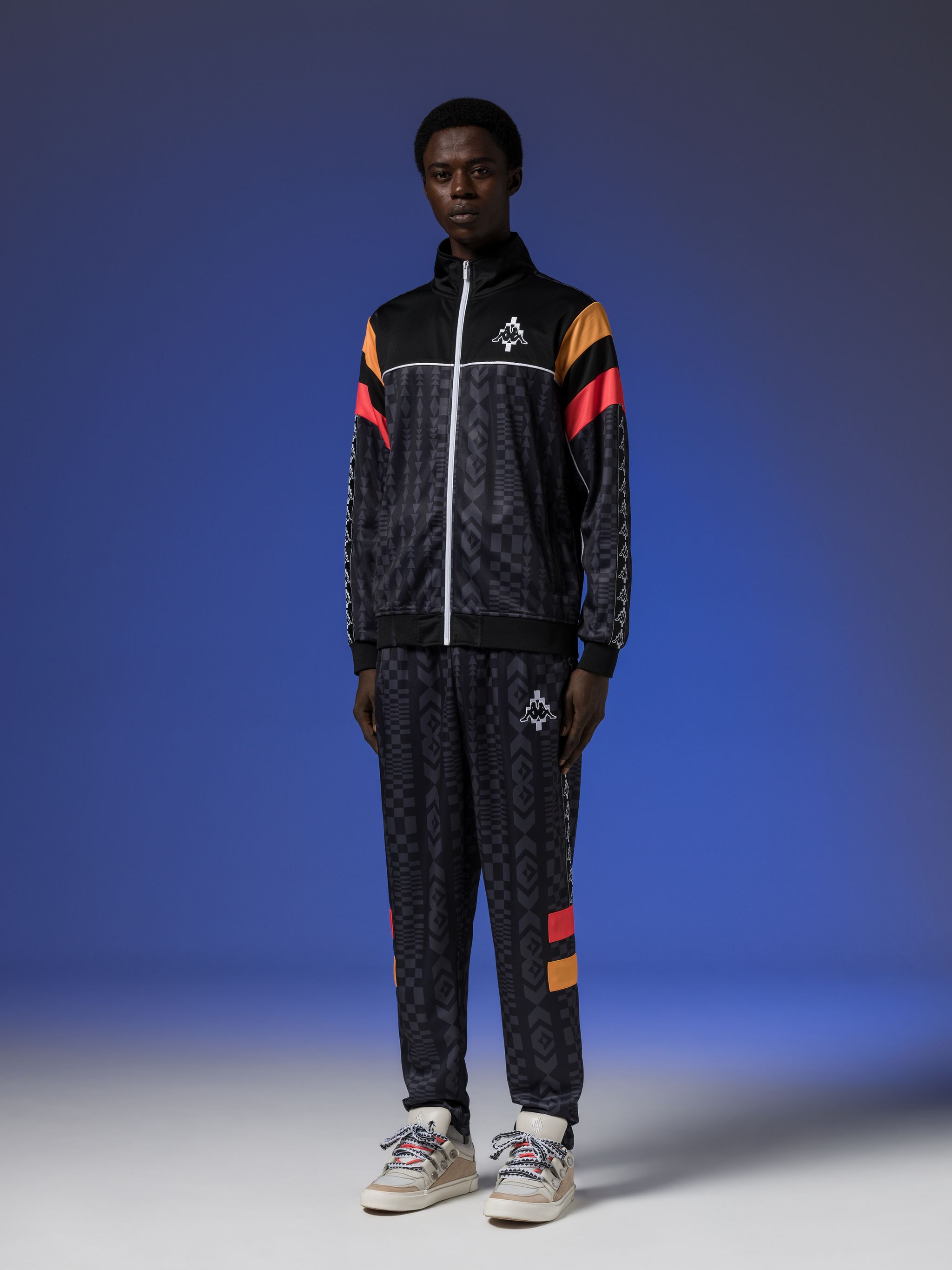 x KAPPA logo-patch jacket from Marcelo Burlon County of Milan featuring black/multicolour, geometric print, logo patch at the chest, logo-tape detailing, high neck, front zip fastening, long sleeves and two side zip-fastening pockets.