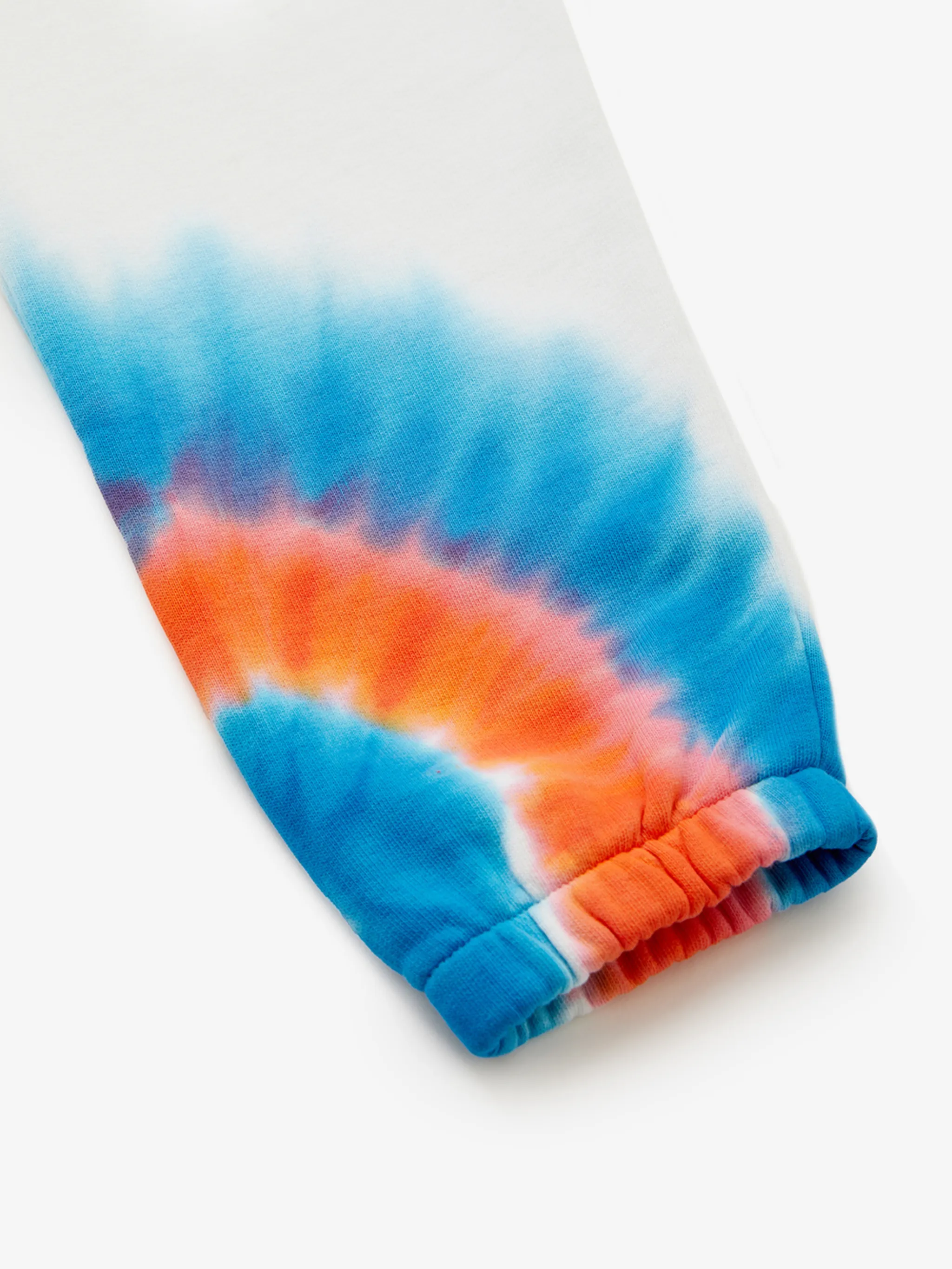 tie-dye cotton track pants from Marcelo Burlon Kids featuring white, orange, blue, cotton, tie-dye pattern, elasticated waistband, two side inset pockets and elasticated ankles. Conscious: This item is made from at least 50% organic materials.