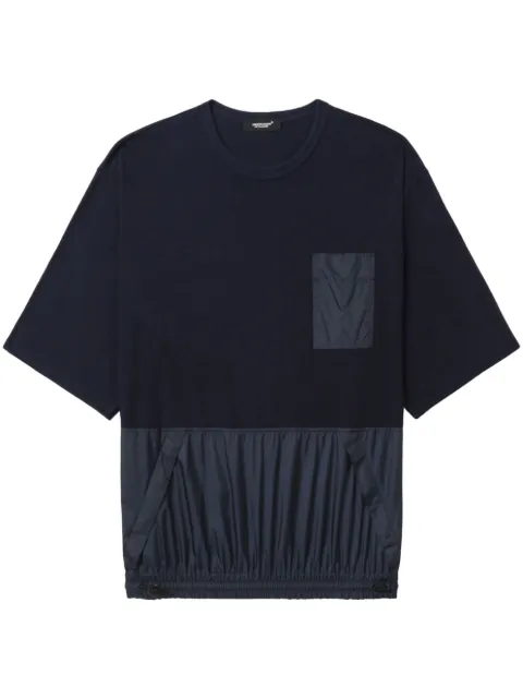 Undercover playera con bolsillos y paneles 