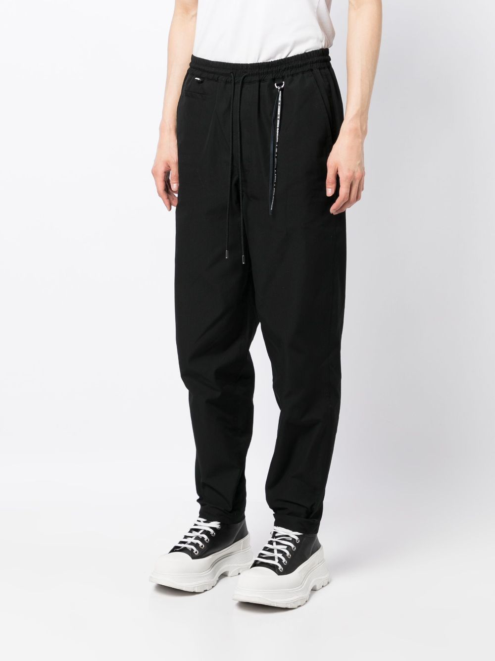 Shop Mastermind Japan Logo-print Tapered-leg Trousers In Black