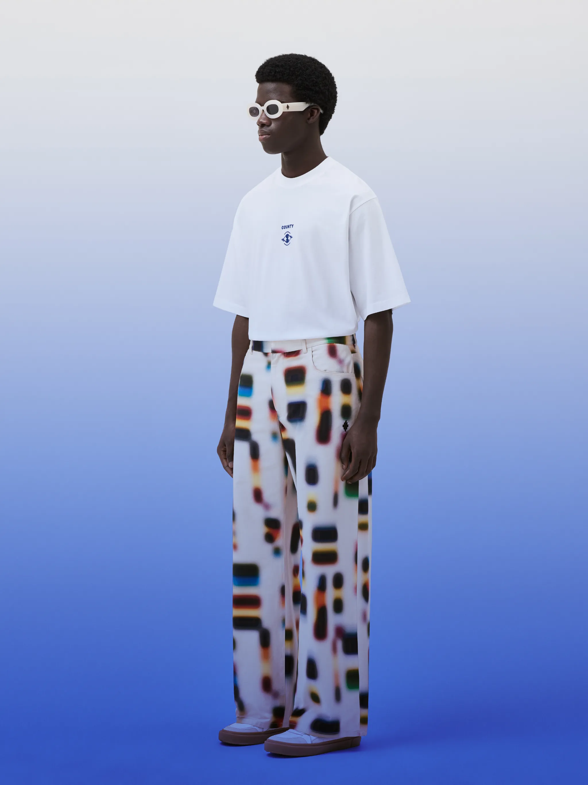 Aop Spectrum wide-leg cotton trousers from Marcelo Burlon County of Milan featuring white/multicolour, cotton, multicolour print, signature Cross motif, wide leg, belt loops, concealed fly and button fastening and classic five pockets.