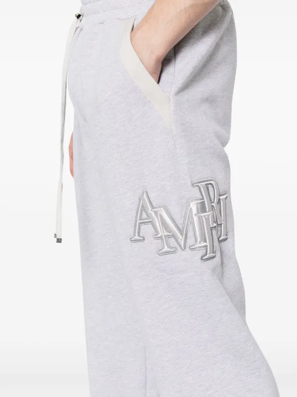 AMIRI Staggered logo-embroidered Track Pants | Grey | FARFETCH