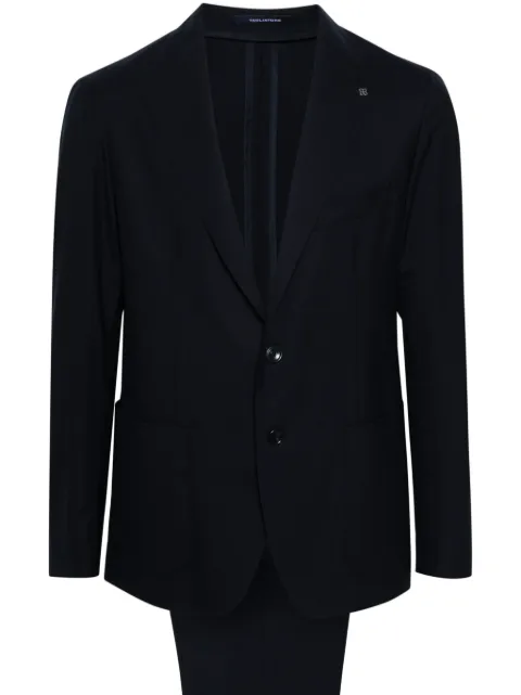 Tagliatore traje con detalle de broche