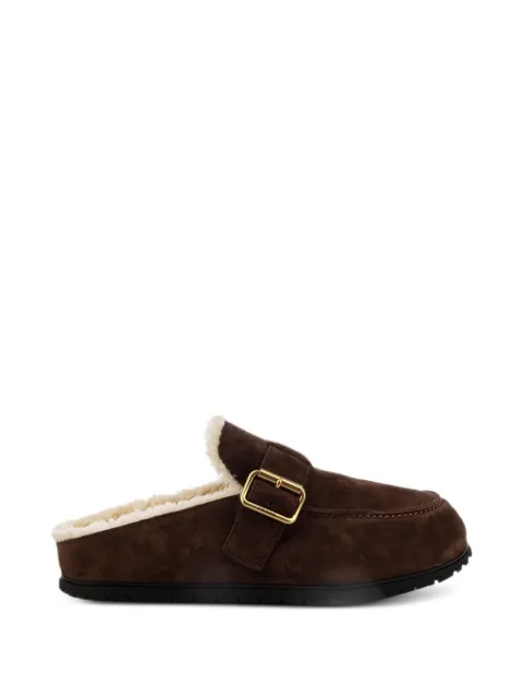 Prada slippers con cierre de hebilla y forro de piel de borrego