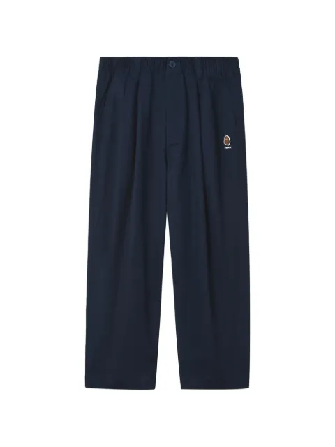 FINGERCROXX pleated logo-patch trousers