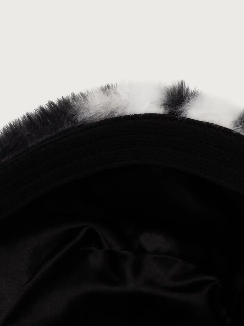 Kangol Vissershoed van imitatiebont met koeien-print Zwart