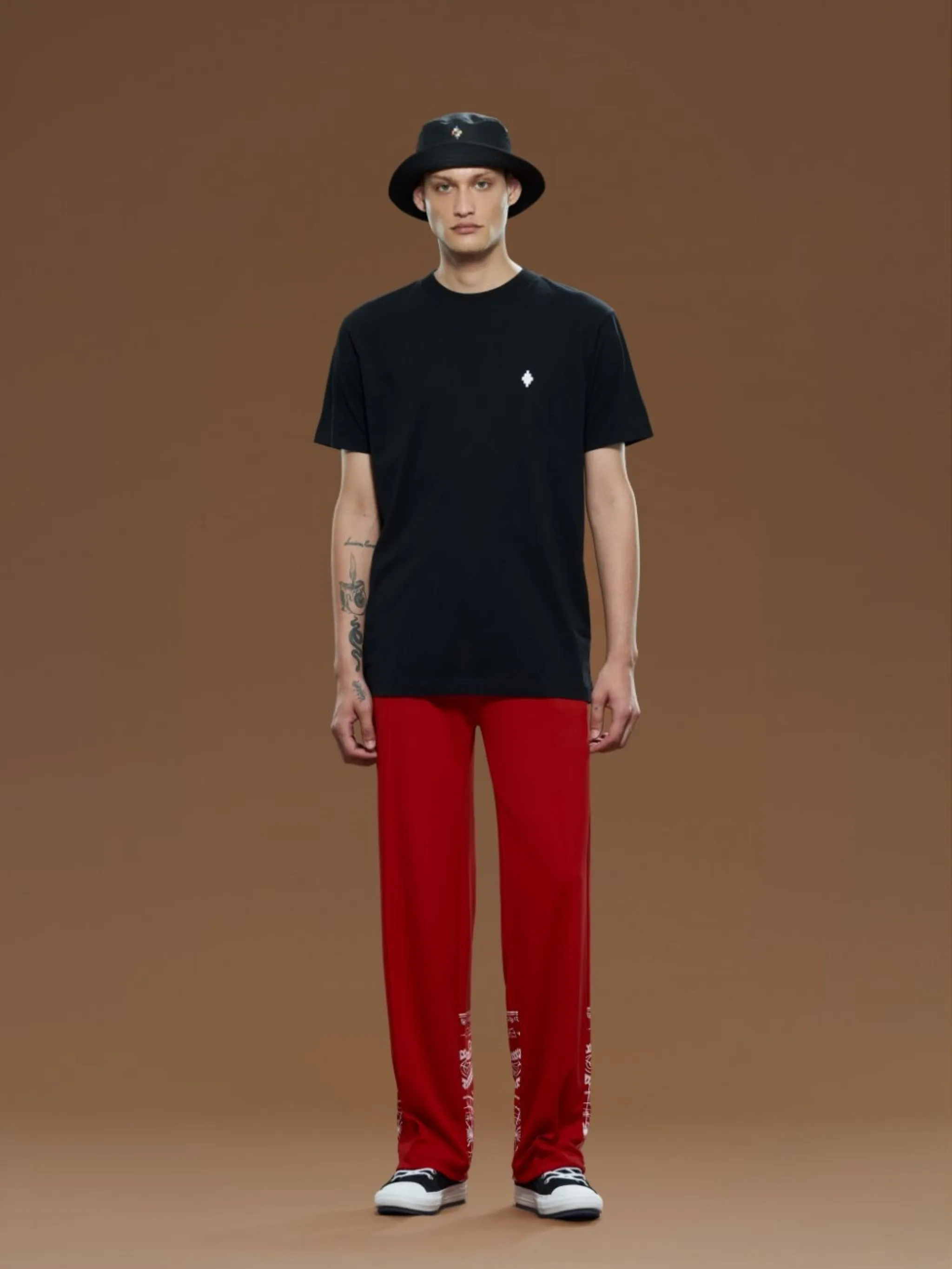 bandana-print track pants from Marcelo Burlon County of Milan featuring bright red, white, bandana print, logo patch to the side, elasticated waistband, two diagonal pockets to the sides, rear jetted pocket, wide leg and extra-long length.