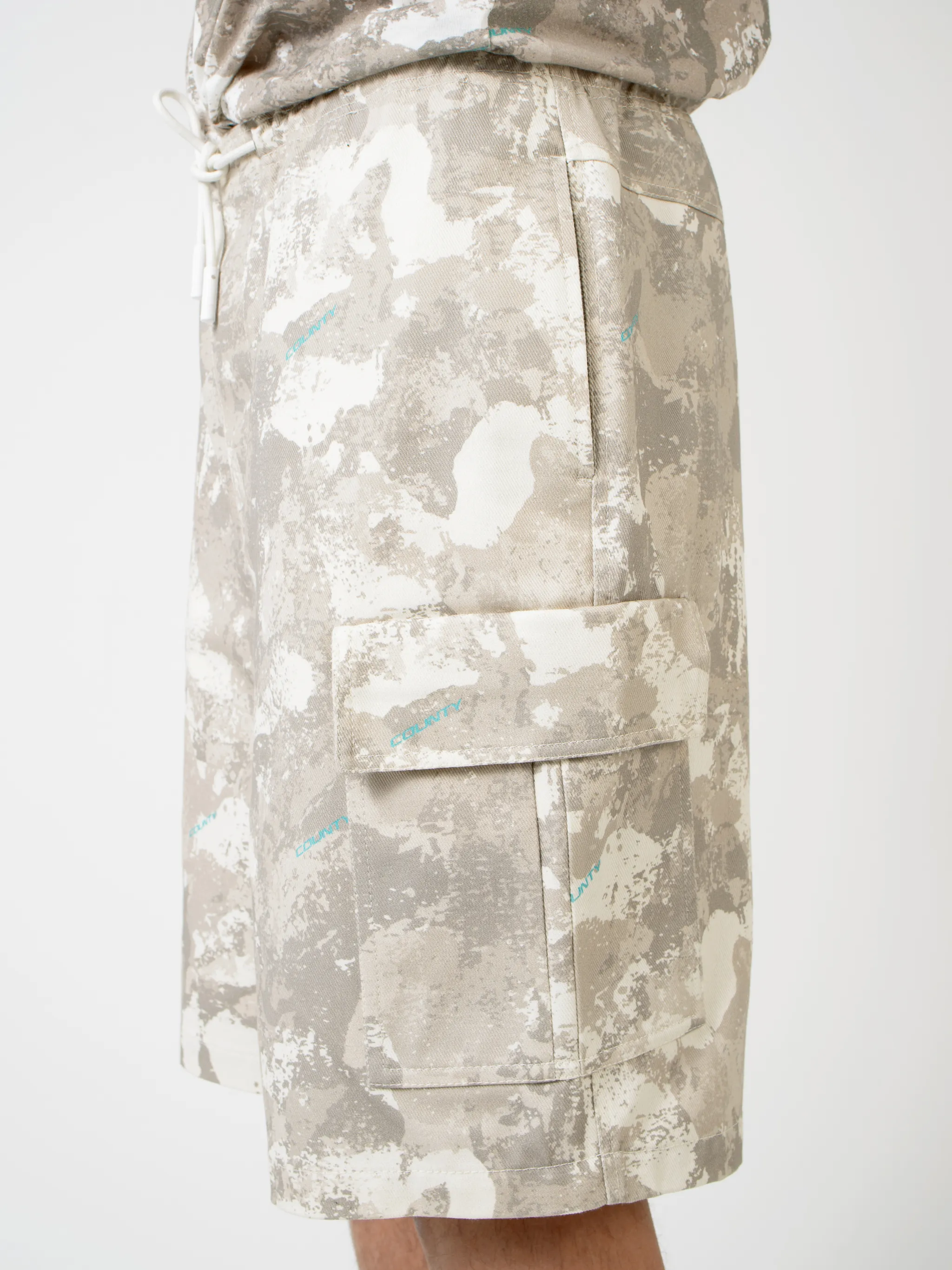 Beige cotton camouflage-print cargo shorts from Marcelo Burlon County of Milan featuring camouflage print, elasticated waistband, drawstring fastening, straight leg, knee-length, two side slash pockets and two side cargo pockets.