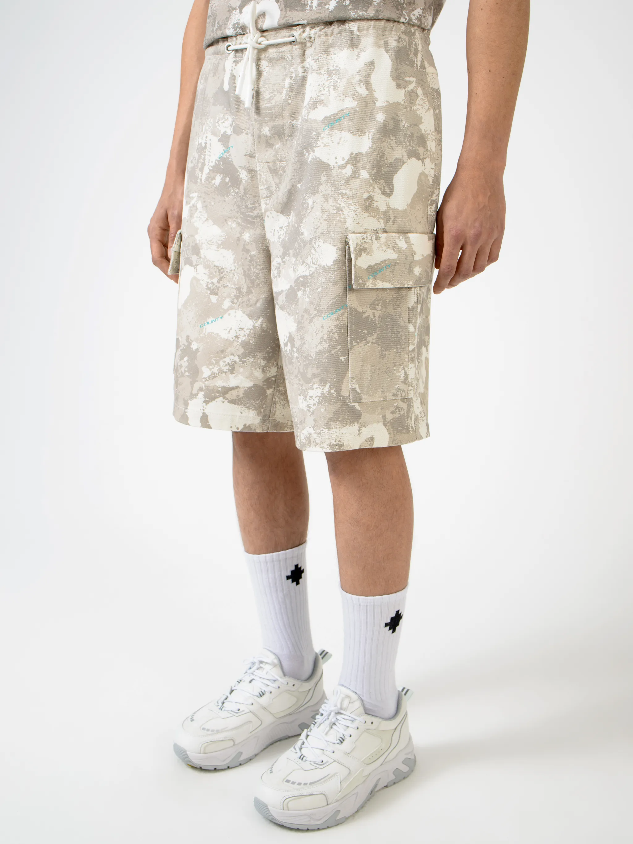 Beige cotton camouflage-print cargo shorts from Marcelo Burlon County of Milan featuring camouflage print, elasticated waistband, drawstring fastening, straight leg, knee-length, two side slash pockets and two side cargo pockets.