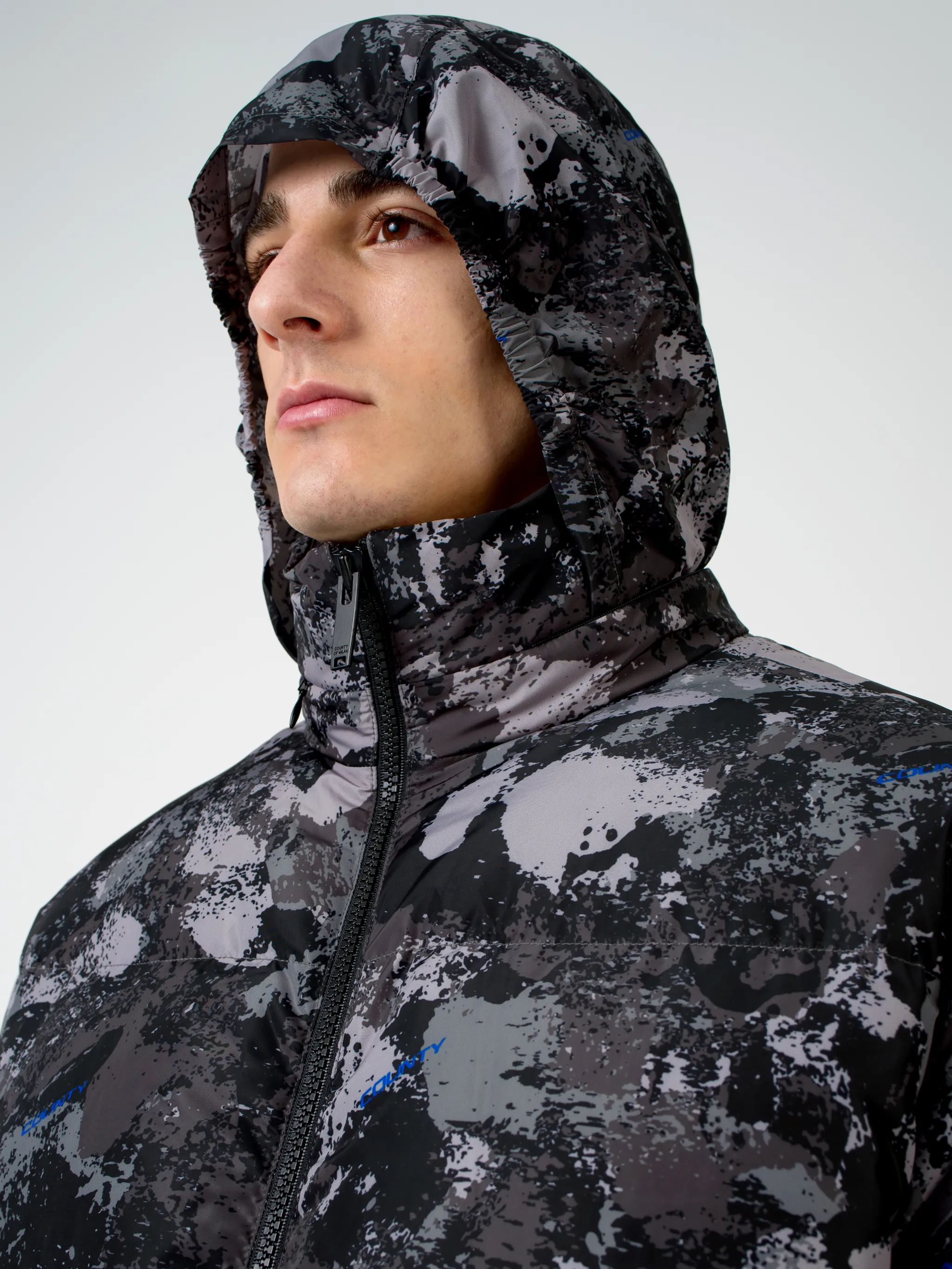 Tonal grey/royal blue camouflage print padded jacket from Marcelo Burlon County of Milan featuring camouflage print, stand-up collar, front zip fastening, two side patch pockets, long sleeves, elasticated cuffs and straight hem.