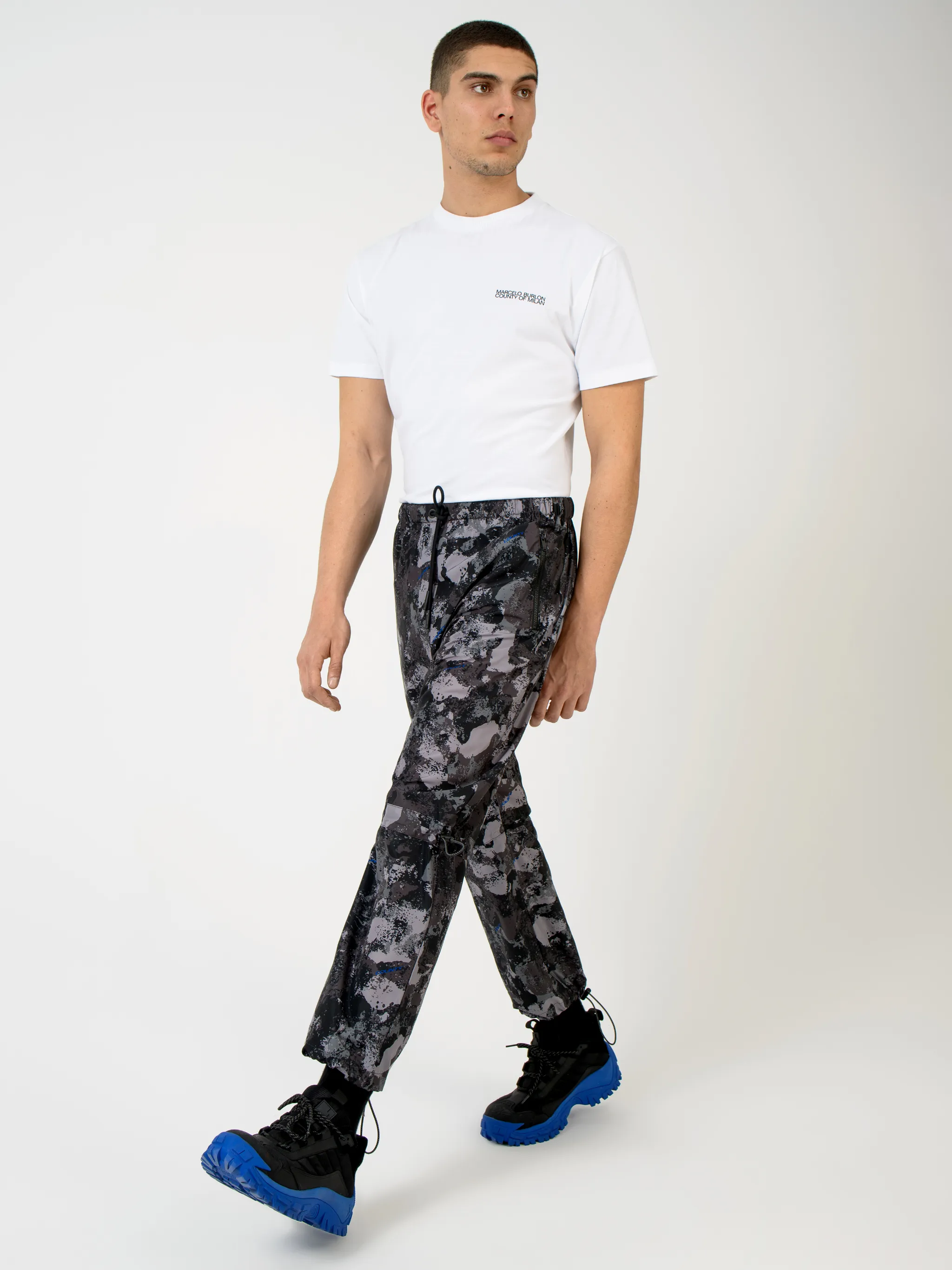 Dark grey high-rise camouflage-print track pants from MARCELO BURLON COUNTY OF MILAN featuring camouflage pattern, high waist, drawstring fastening waist, two side slit pockets, straight leg and ankle-length.