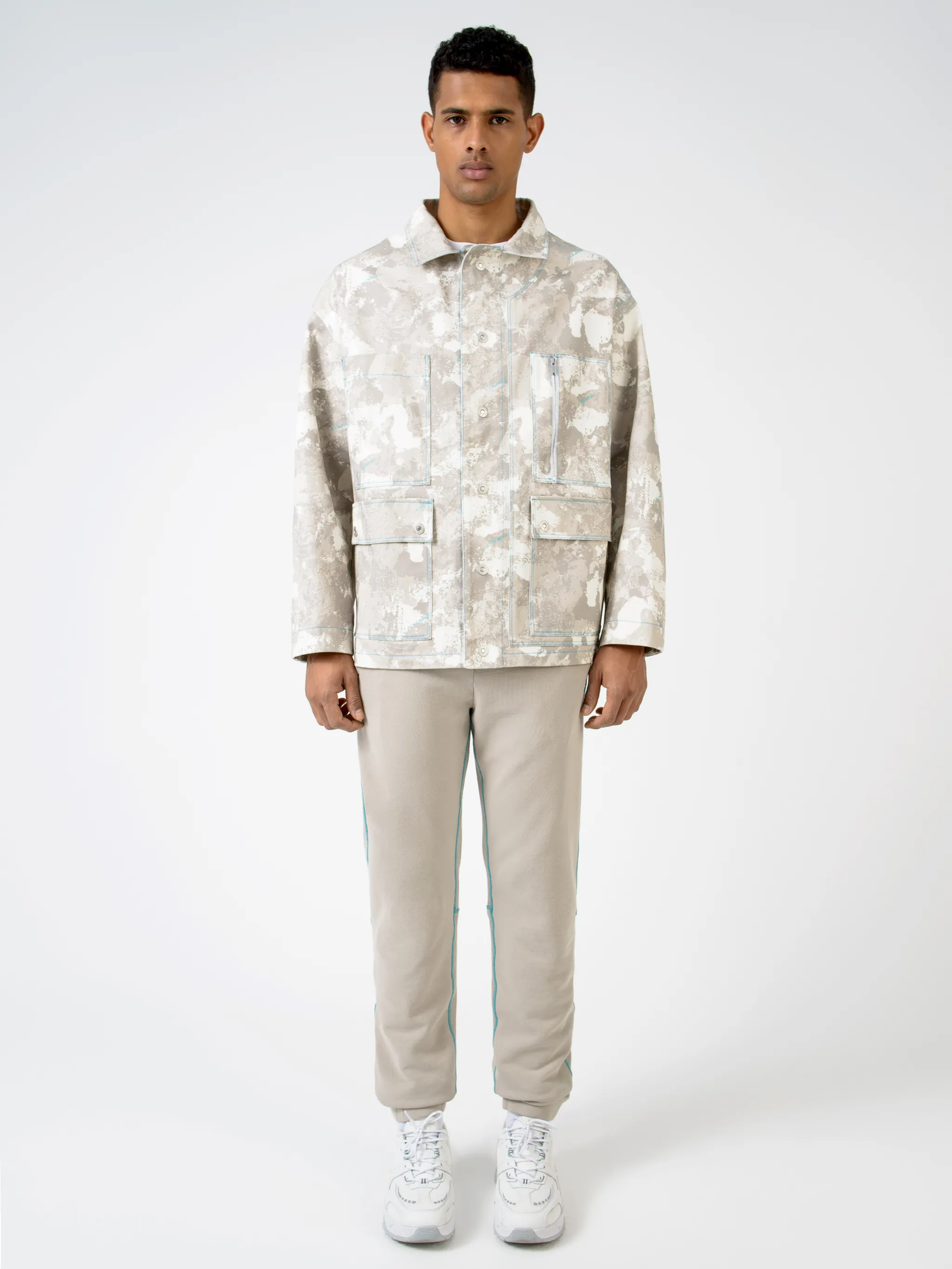 Tonal-beige cotton camouflage print military jacket from Marcelo Burlon County of Milan featuring camouflage print, classic collar, front button fastening, chest patch pocket, zip-fastening chest pocket, two side button-fastening pockets, long sleeves, buttoned cuffs and straight hem.
