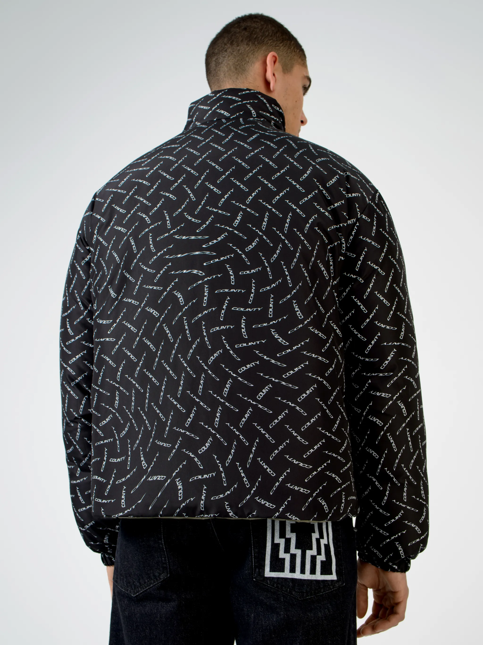 Black/white County logo print padded jacket from Marcelo Burlon County of Milan featuring all-over logo print, padded design, high neck, front zip fastening, two side patch pockets, long sleeves and straight hem.