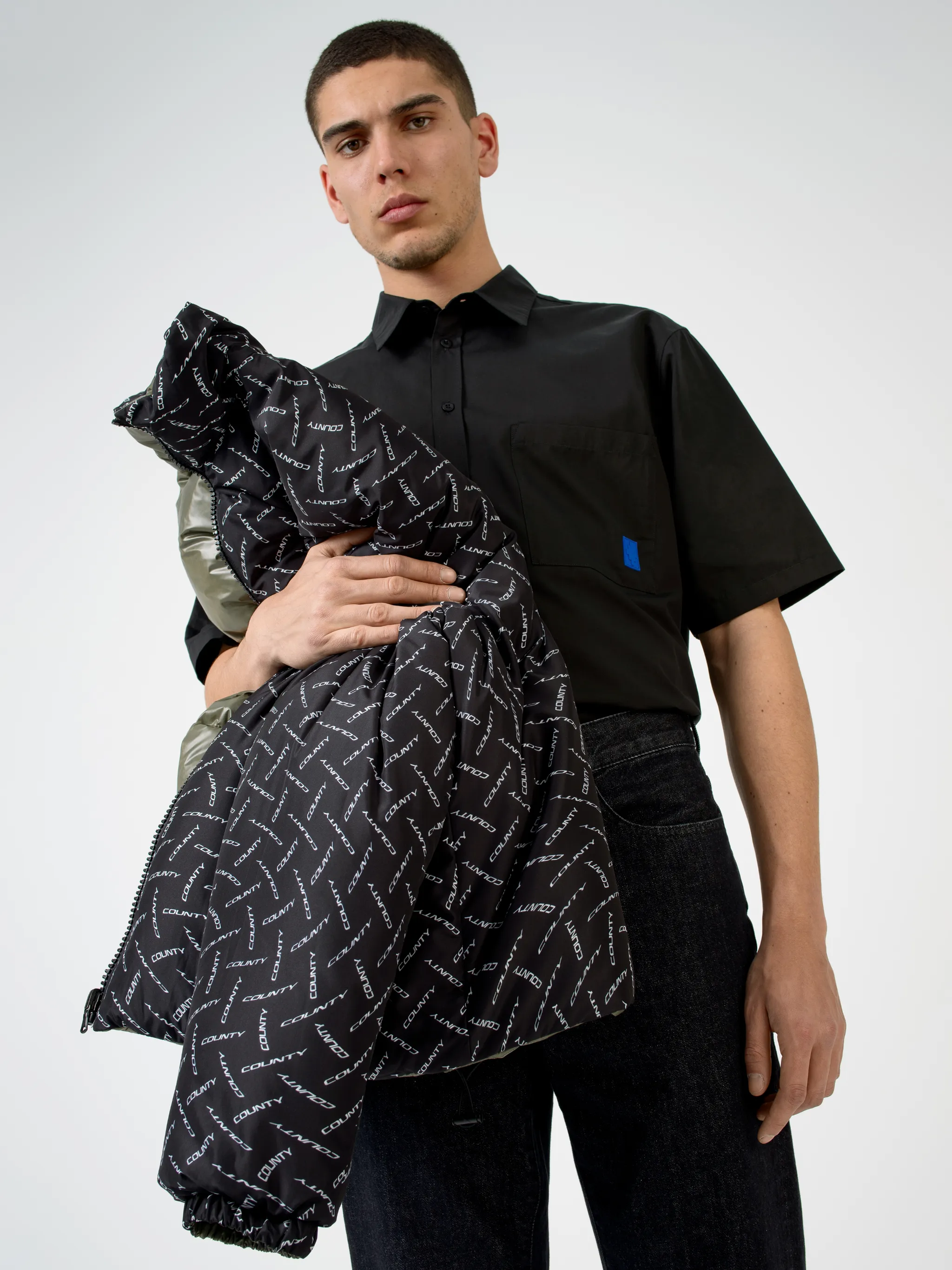 Black/white County logo print padded jacket from Marcelo Burlon County of Milan featuring all-over logo print, padded design, high neck, front zip fastening, two side patch pockets, long sleeves and straight hem.