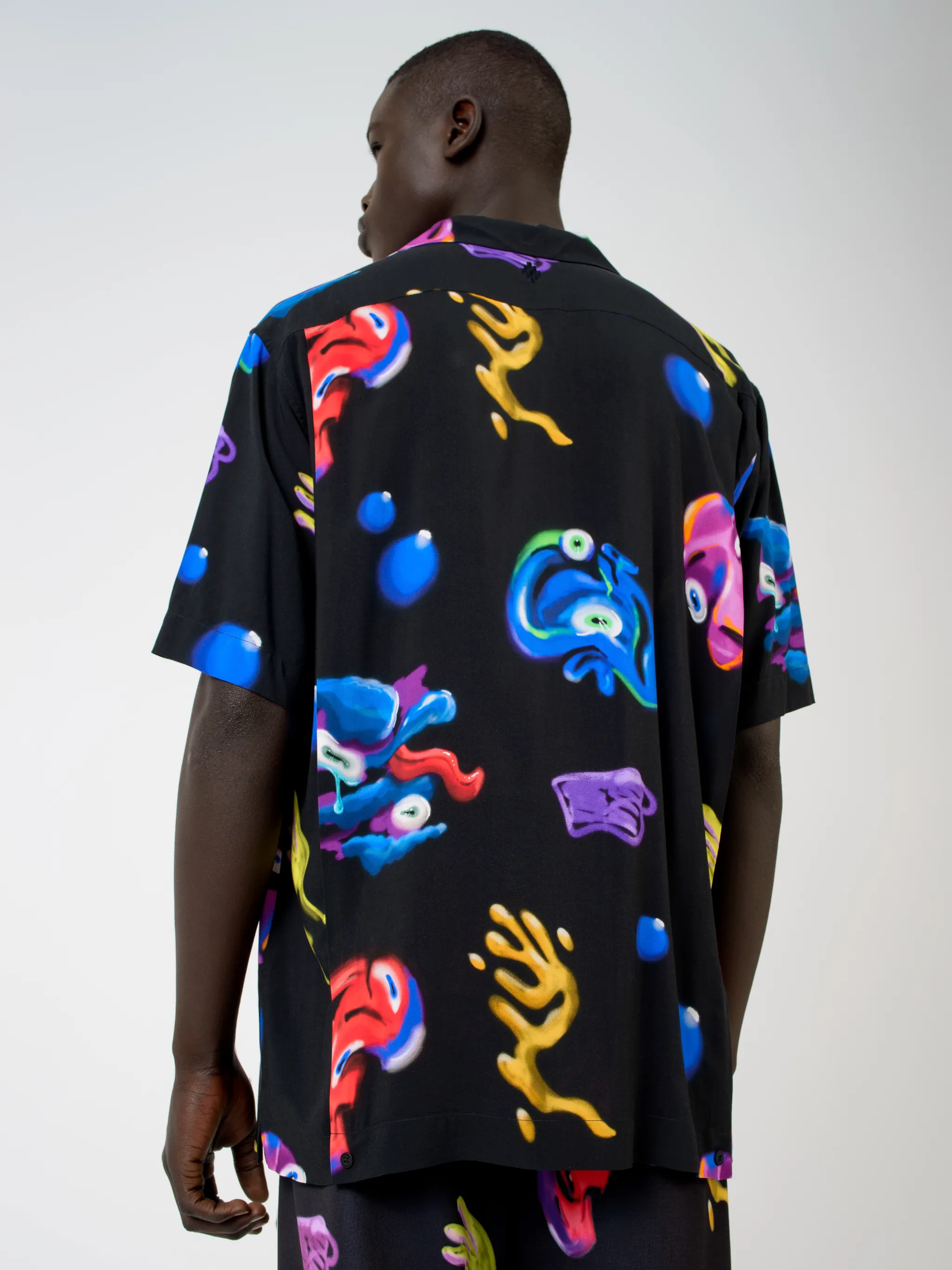 Black/multicolour Crazy Faces print shirt from Marcelo Burlon County of Milan featuring all-over logo print, spread collar, concealed front fastening, short sleeves and straight hem.