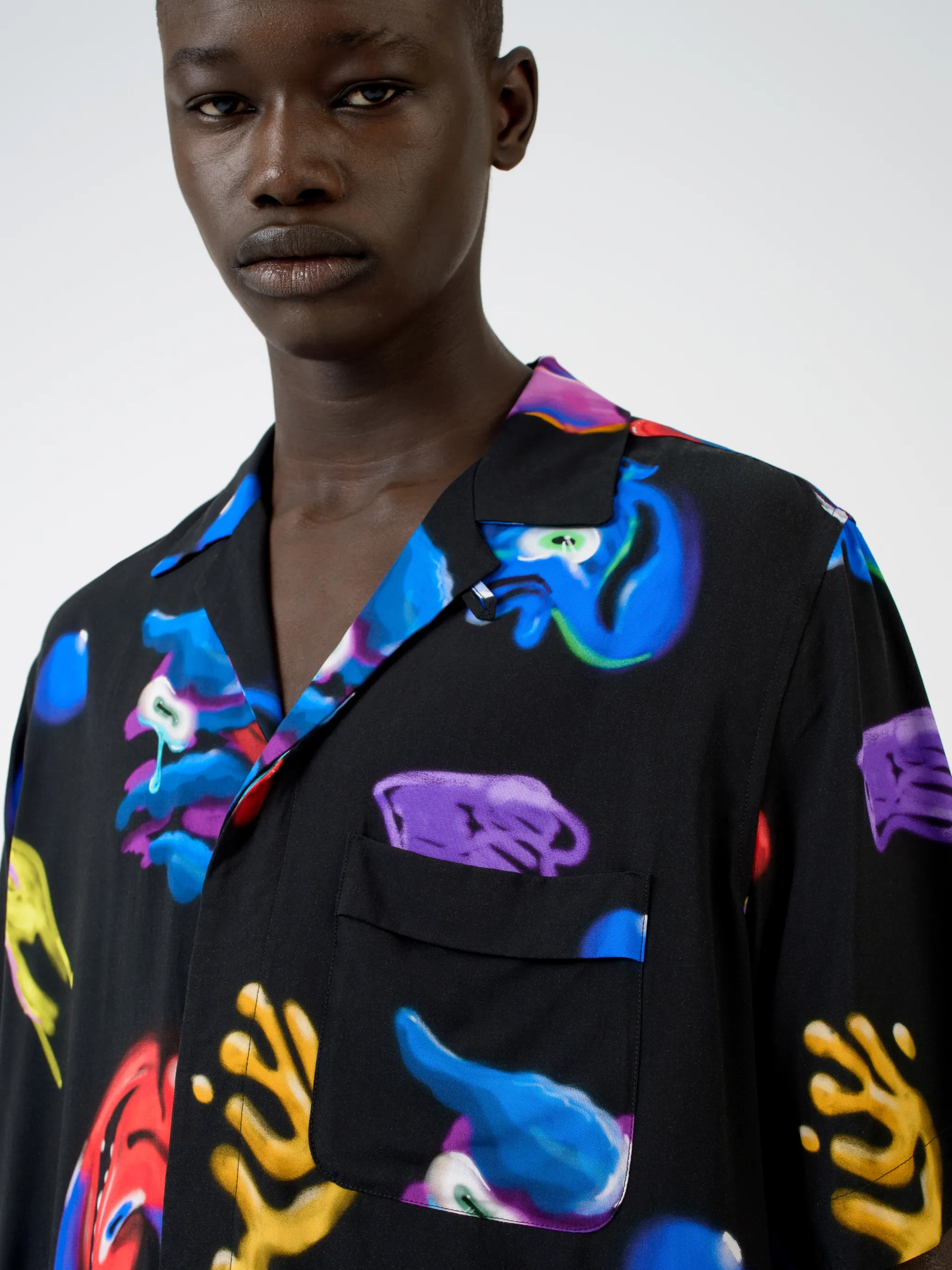 Black/multicolour Crazy Faces print shirt from Marcelo Burlon County of Milan featuring all-over logo print, spread collar, concealed front fastening, short sleeves and straight hem.