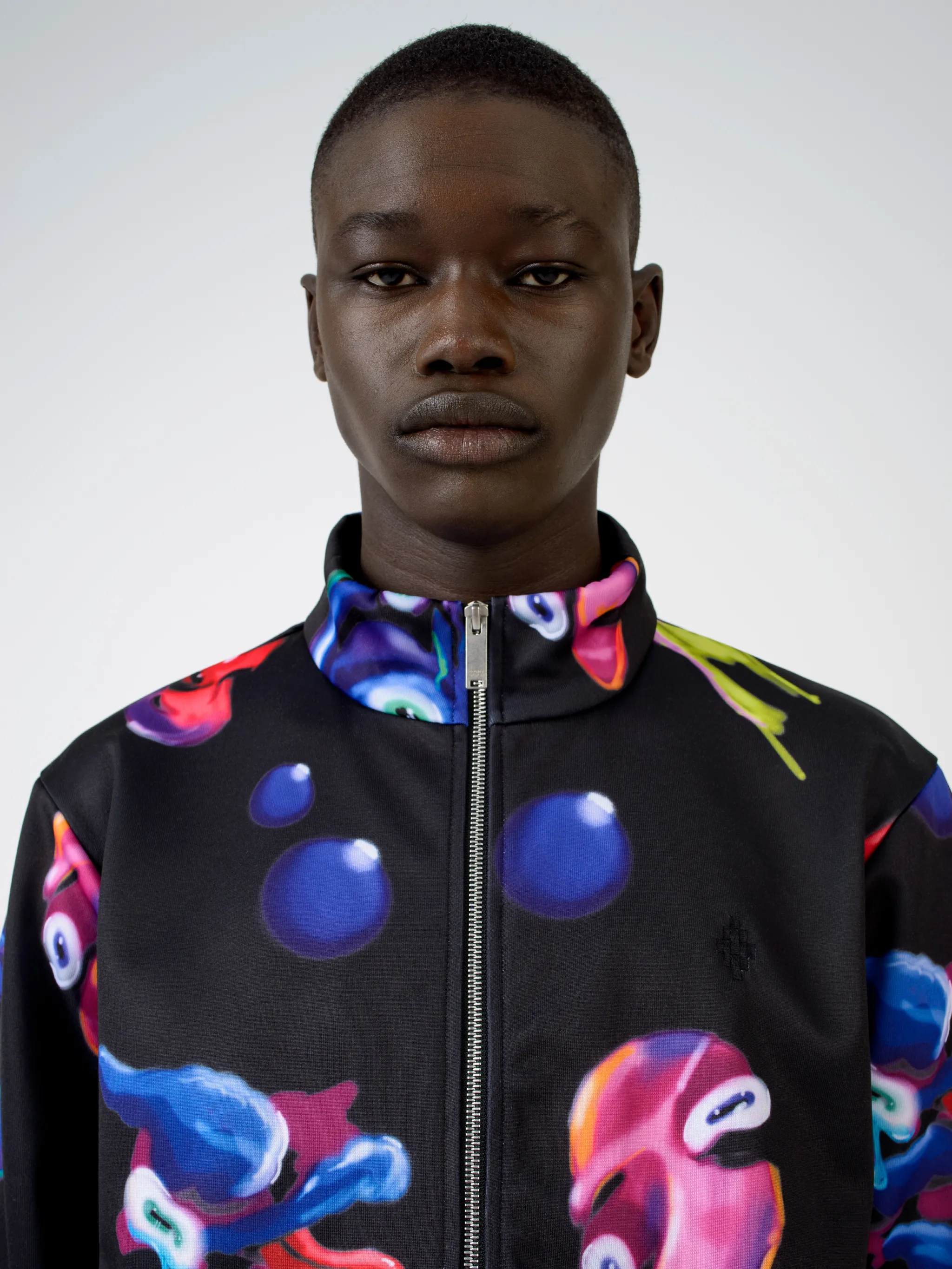 Black/multicolour cotton-blend Crazy Faces print jacket from Marcelo Burlon County of Milan featuring graphic print, stand-up collar, front zip fastening, two side patch pockets, long sleeves and straight hem.