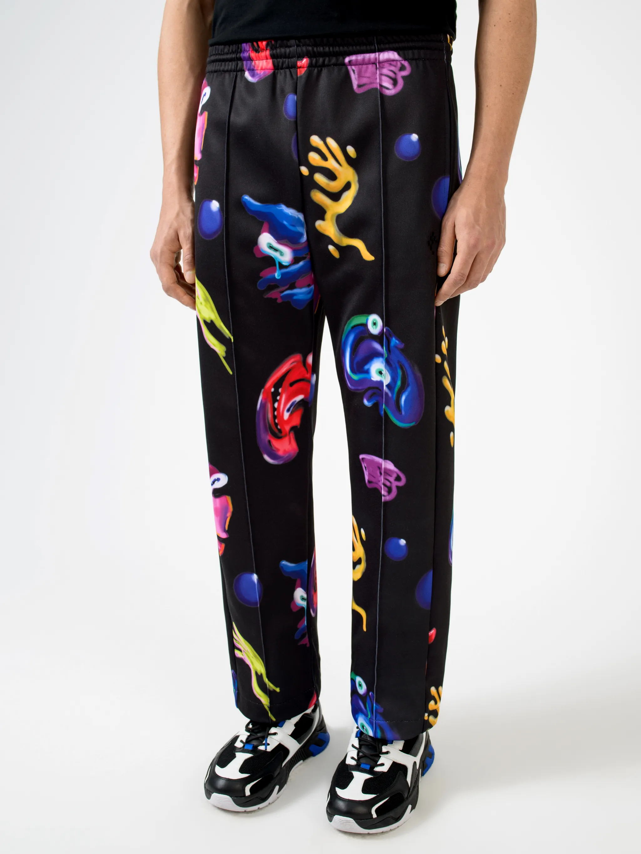 Black/multicolour cotton-blend Crazy Faces print track pants from Marcelo Burlon County of Milan featuring graphic print, elasticated waistband, drawstring fastening, piped-trim detailing, two side patch pockets and straight leg.