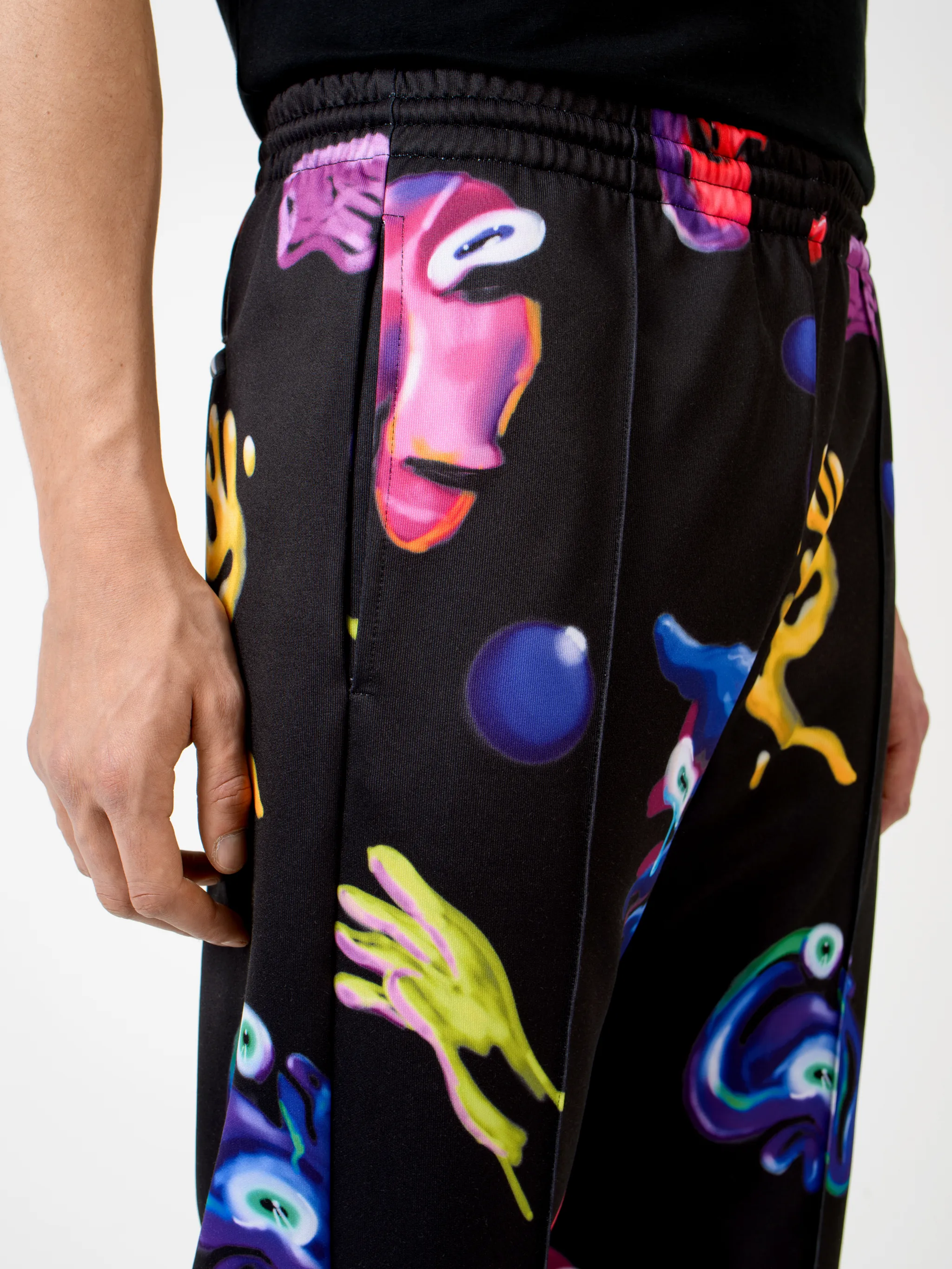 Black/multicolour cotton-blend Crazy Faces print track pants from Marcelo Burlon County of Milan featuring graphic print, elasticated waistband, drawstring fastening, piped-trim detailing, two side patch pockets and straight leg.
