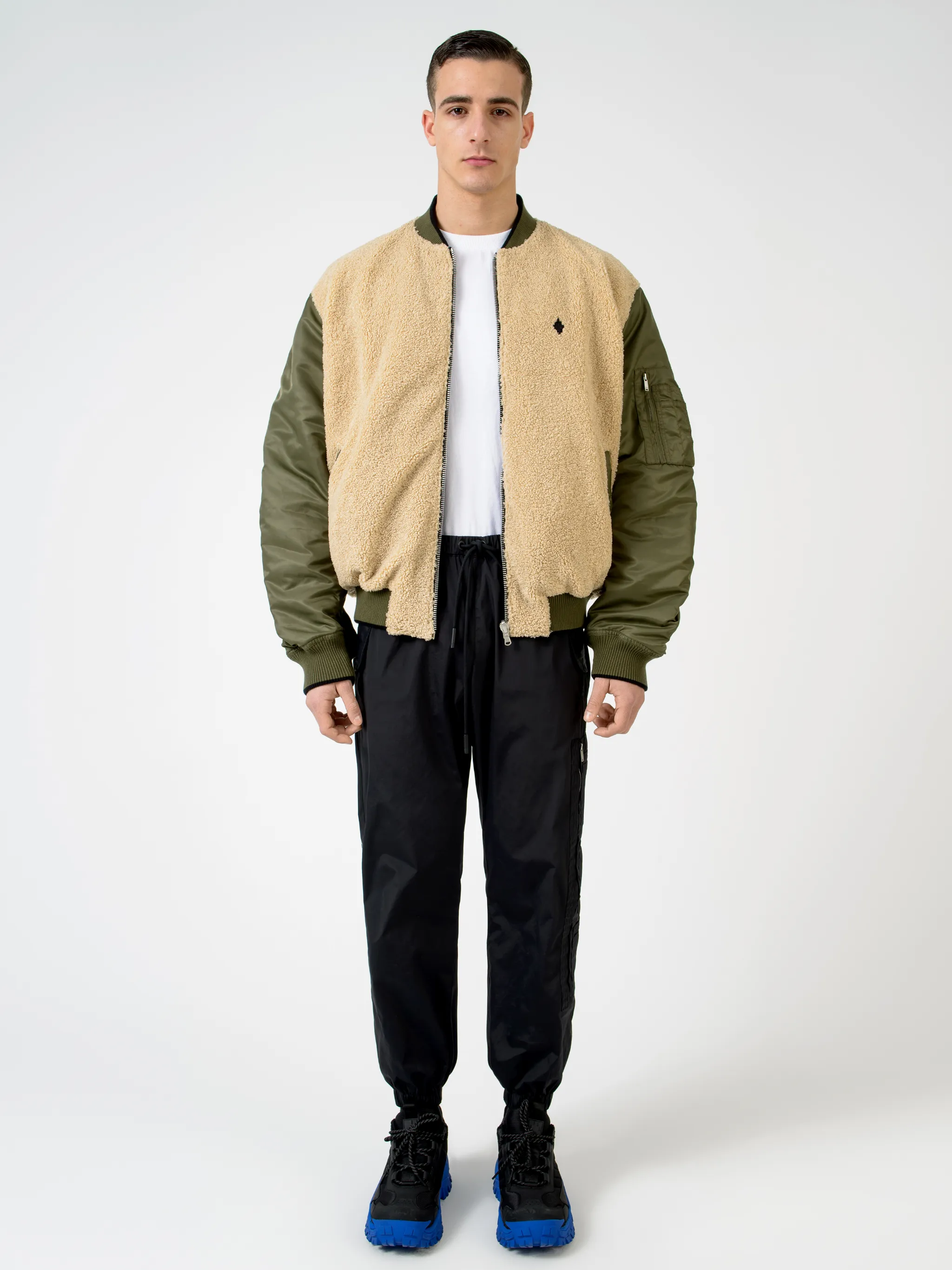 Army green/beige/black reversible panelled bomber jacket from Marcelo Burlon County of Milan featuring reversible, panelled design, embroidered logo to the rear, embroidered logo at the chest, ruched detailing, long sleeves, front zip fastening, two side slit pockets and ribbed edge.