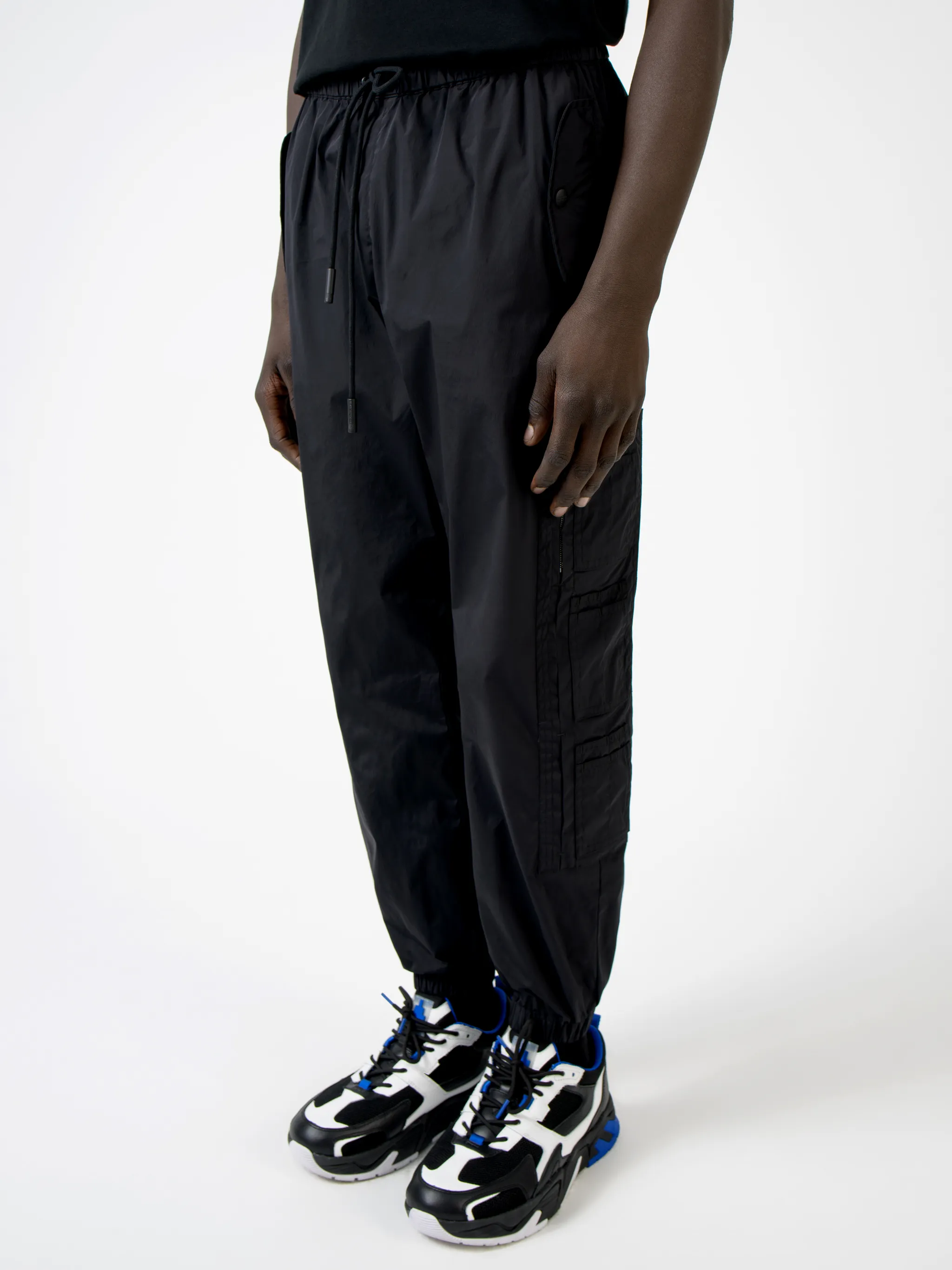 Black Cross tapered track pants from Marcelo Burlon County of Milan featuring embroidered logo to the front, elasticated ankles, elasticated waistband, tapered fit, two side slit pockets and two zip-fastening pockets to the side.