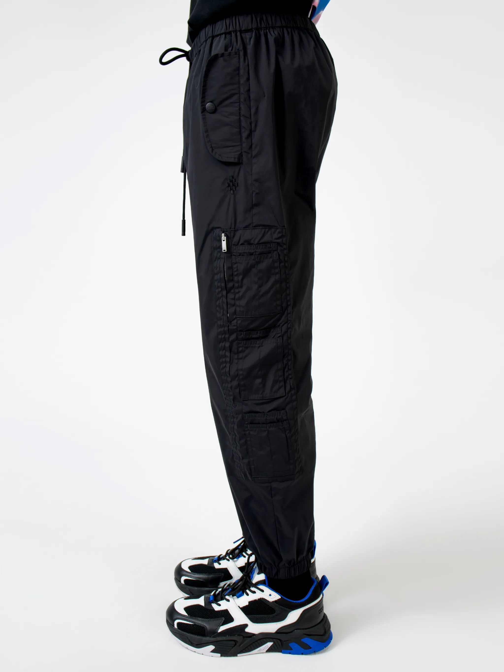 Black Cross tapered track pants from Marcelo Burlon County of Milan featuring embroidered logo to the front, elasticated ankles, elasticated waistband, tapered fit, two side slit pockets and two zip-fastening pockets to the side.
