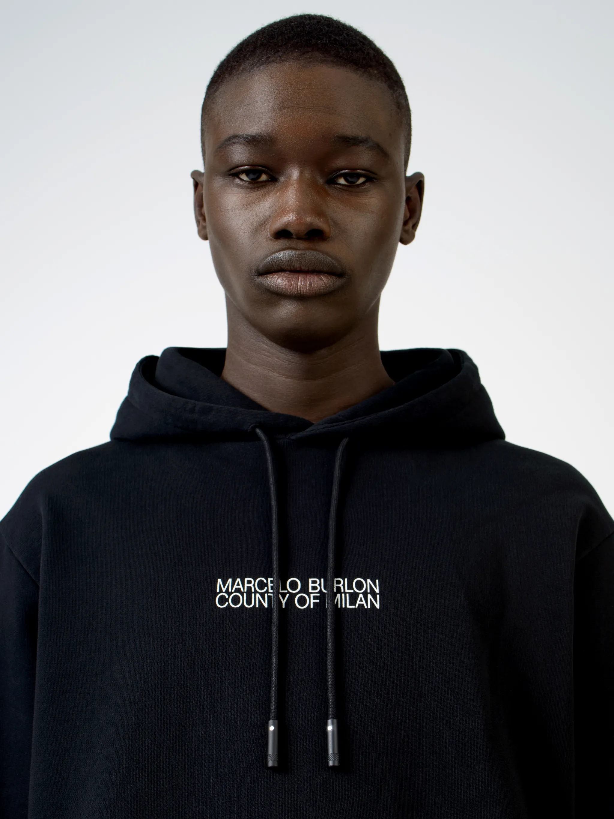 Black cotton Cross Man cotton hoodie from Marcelo Burlon County of Milan featuring logo print to the front, graphic print to the rear, ribbed edge, drawstring hood, long sleeves, front pouch pocket and straight hem.