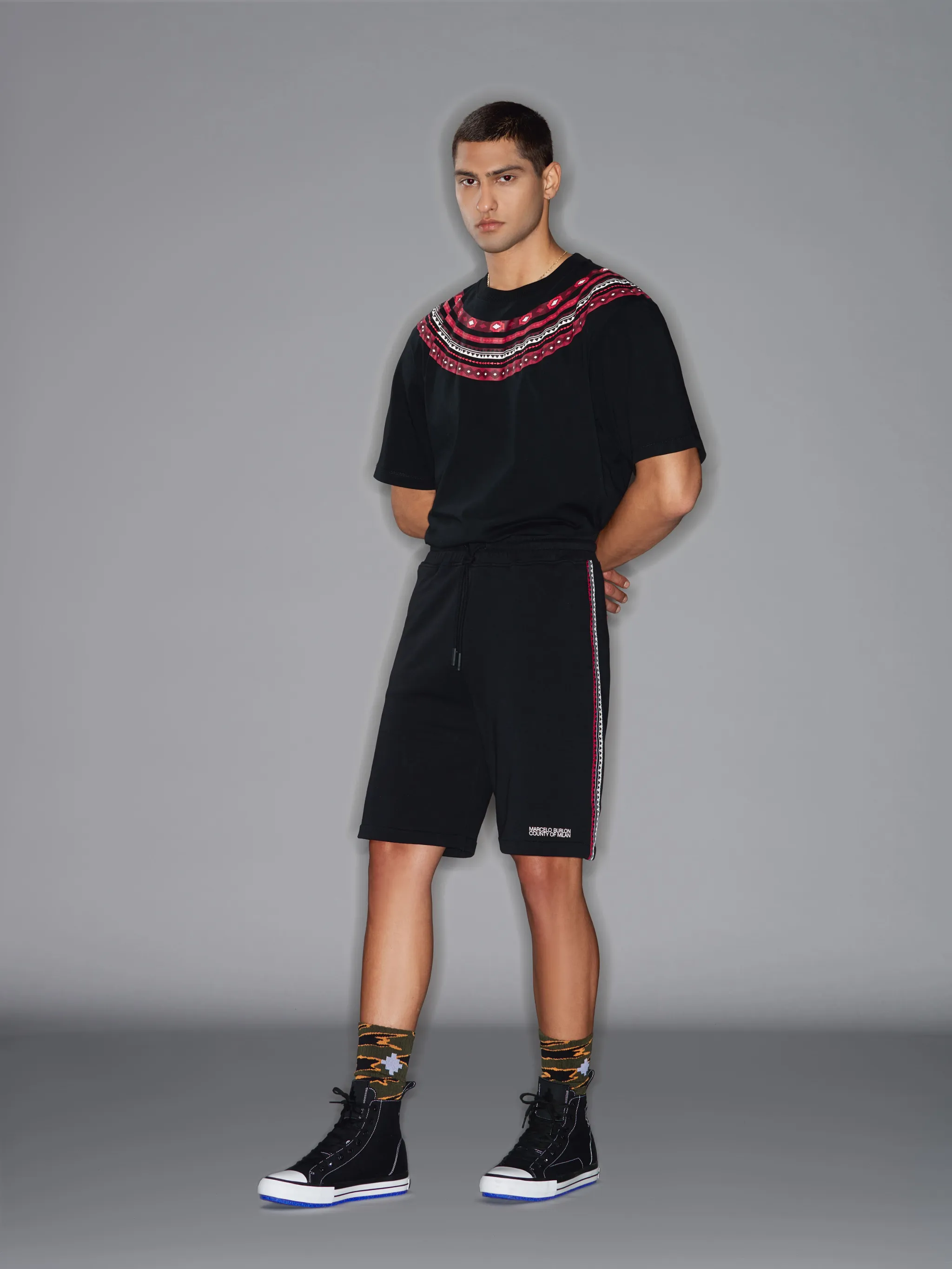 Black/red/white cotton tape-detail track shorts from Marcelo Burlon County of Milan featuring jersey fleece, tape detailing, logo print at the leg, elasticated drawstring waistband, two side slit pockets and rear welt pocket.