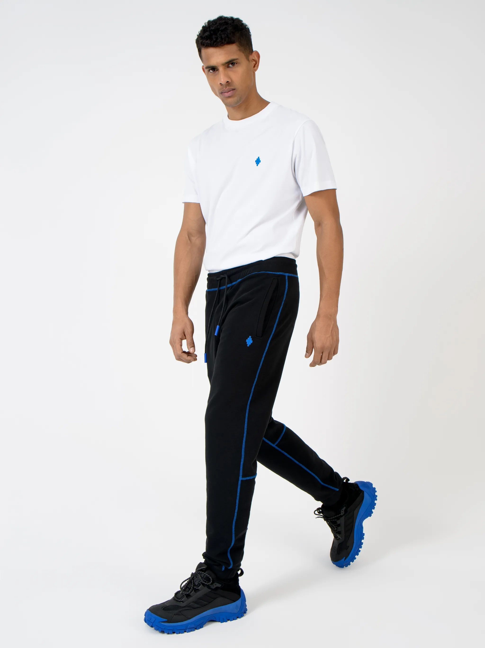 Black cotton Cross contrasting-trim track pants from Marcelo Burlon County of Milan featuring embroidered logo to the front, embroidered logo to the rear, contrasting trim, elasticated ankles, elasticated waistband, tapered design, two side slit pockets and rear welt pocket.