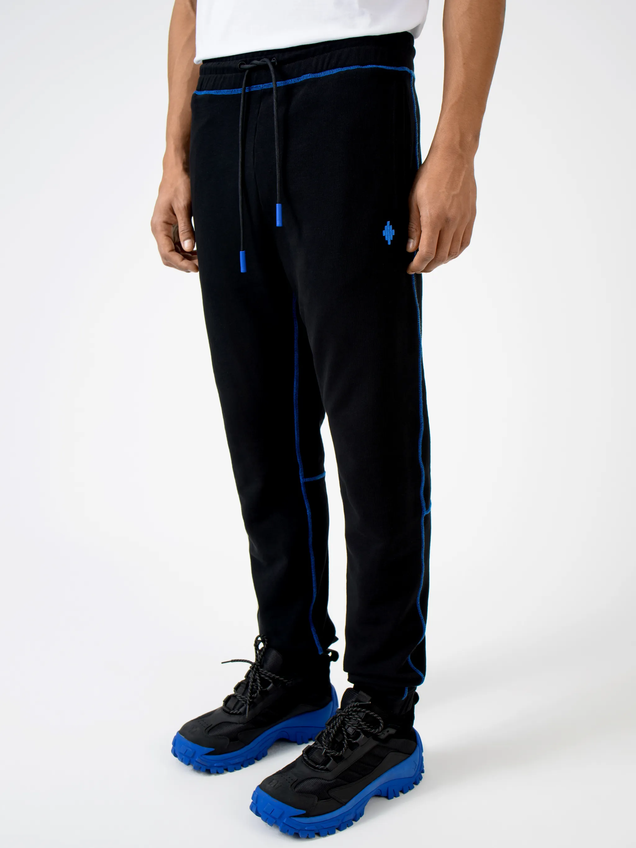 Black cotton Cross contrasting-trim track pants from Marcelo Burlon County of Milan featuring embroidered logo to the front, embroidered logo to the rear, contrasting trim, elasticated ankles, elasticated waistband, tapered design, two side slit pockets and rear welt pocket.