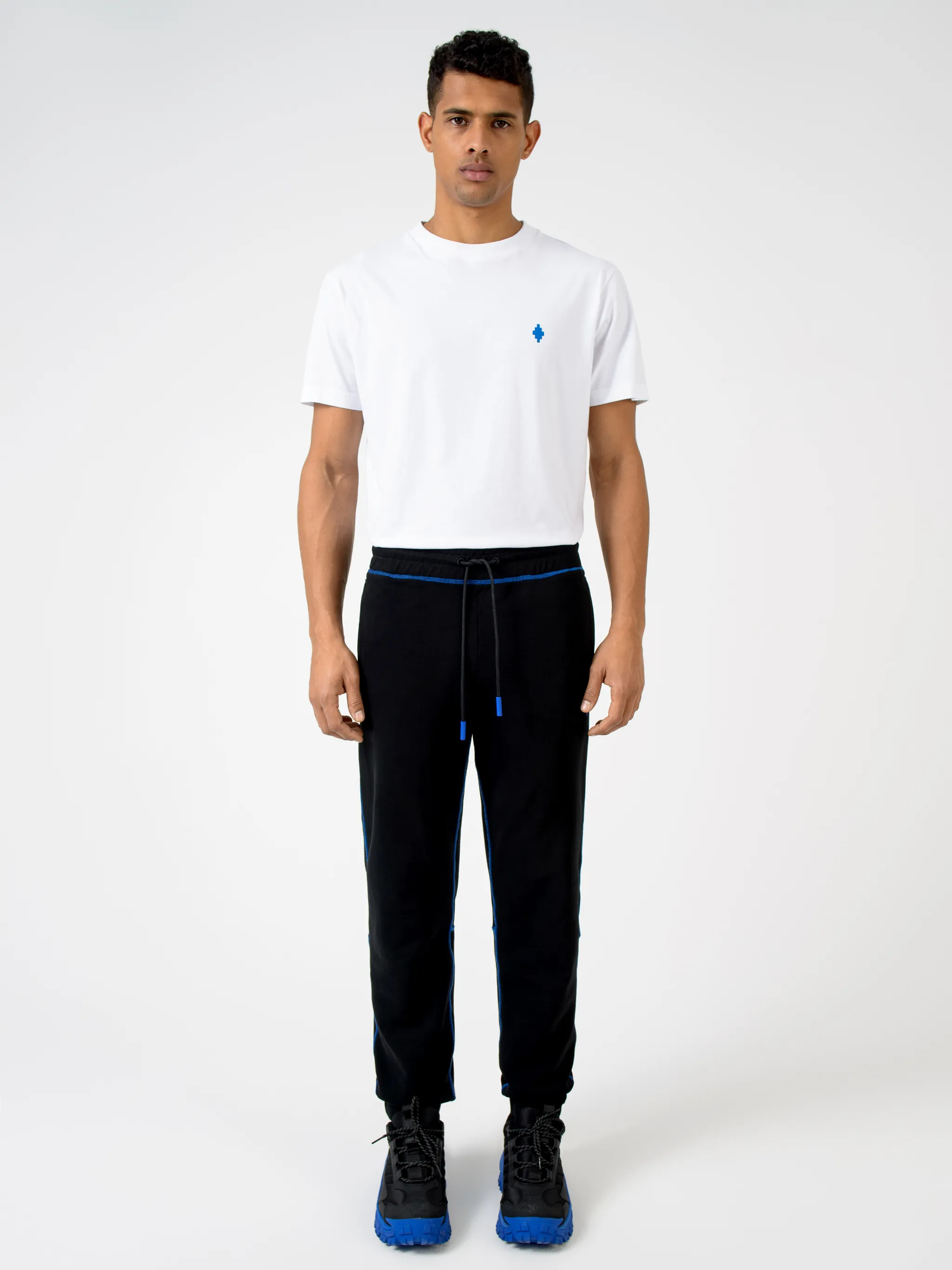 Black cotton Cross contrasting-trim track pants from Marcelo Burlon County of Milan featuring embroidered logo to the front, embroidered logo to the rear, contrasting trim, elasticated ankles, elasticated waistband, tapered design, two side slit pockets and rear welt pocket.