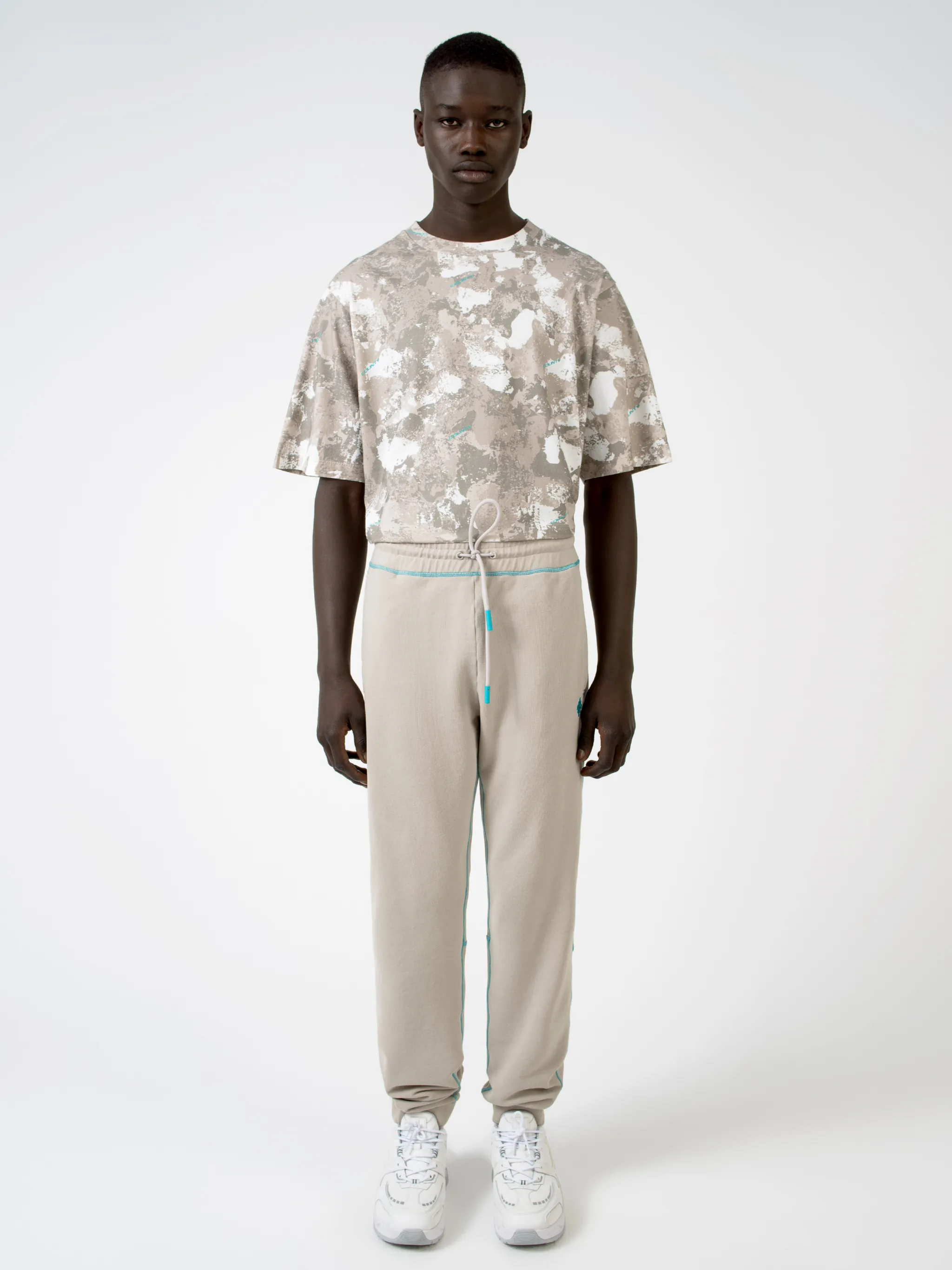 Beige cotton Cross tapered track pants from Marcelo Burlon County of Milan featuring embroidered logo to the rear, contrasting trim, elasticated ankles, elasticated waistband, drawstring fastening, tapered design, two side slit pockets and rear welt pocket.