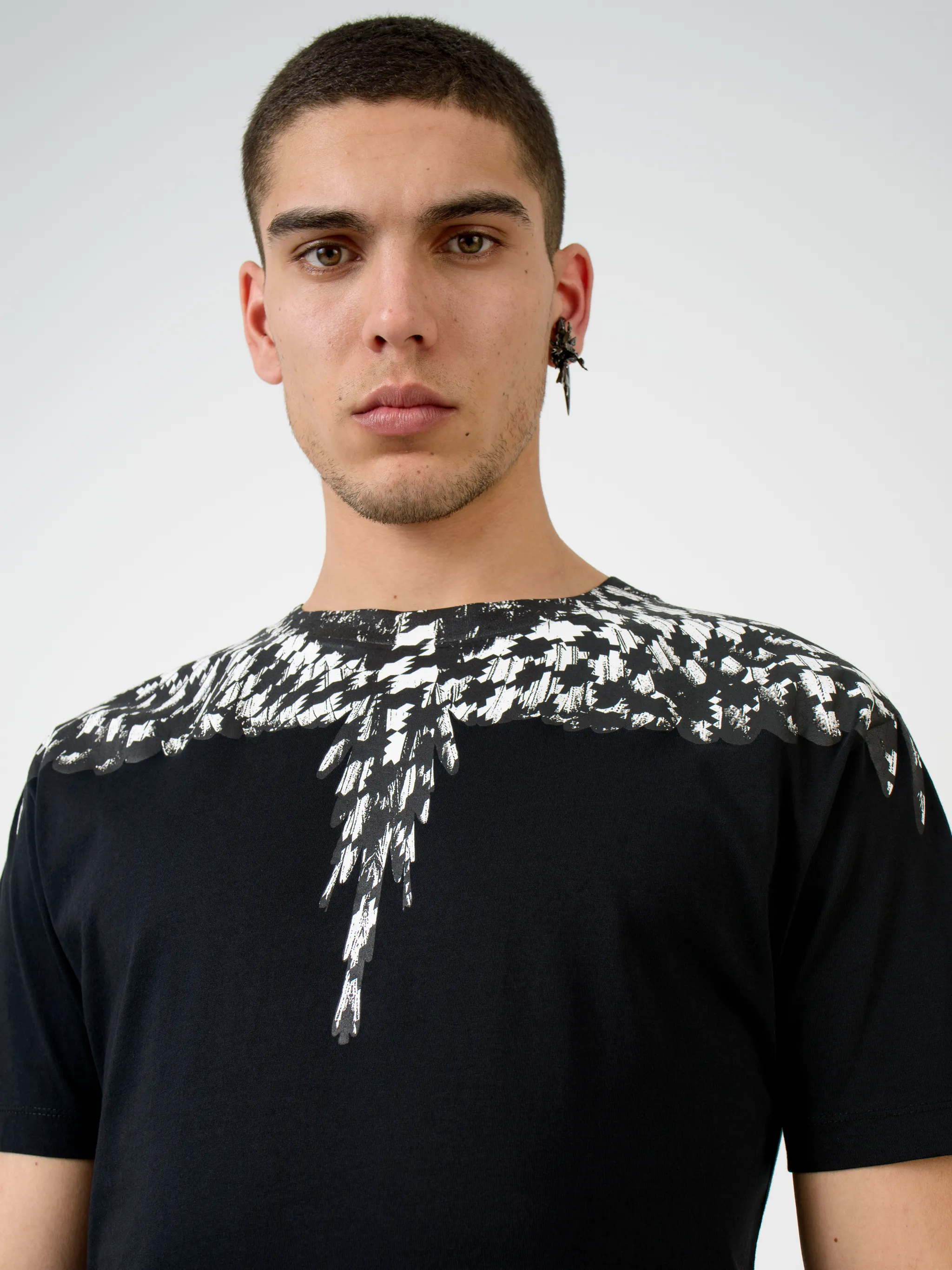 Isn't it about time you spread your wings and take your wardrobe in a different direction? Feel free as a bird with this black cross pattern wings T-shirt from Marcelo Burlon County of Milan that has been crafted with lightweight breathable cotton that keeps you feel fresh throughout the day. Your style is about to take flight. Featuring a ribbed crew neck, a jersey knit, a relaxed fit, a straight hem, and short sleeves.