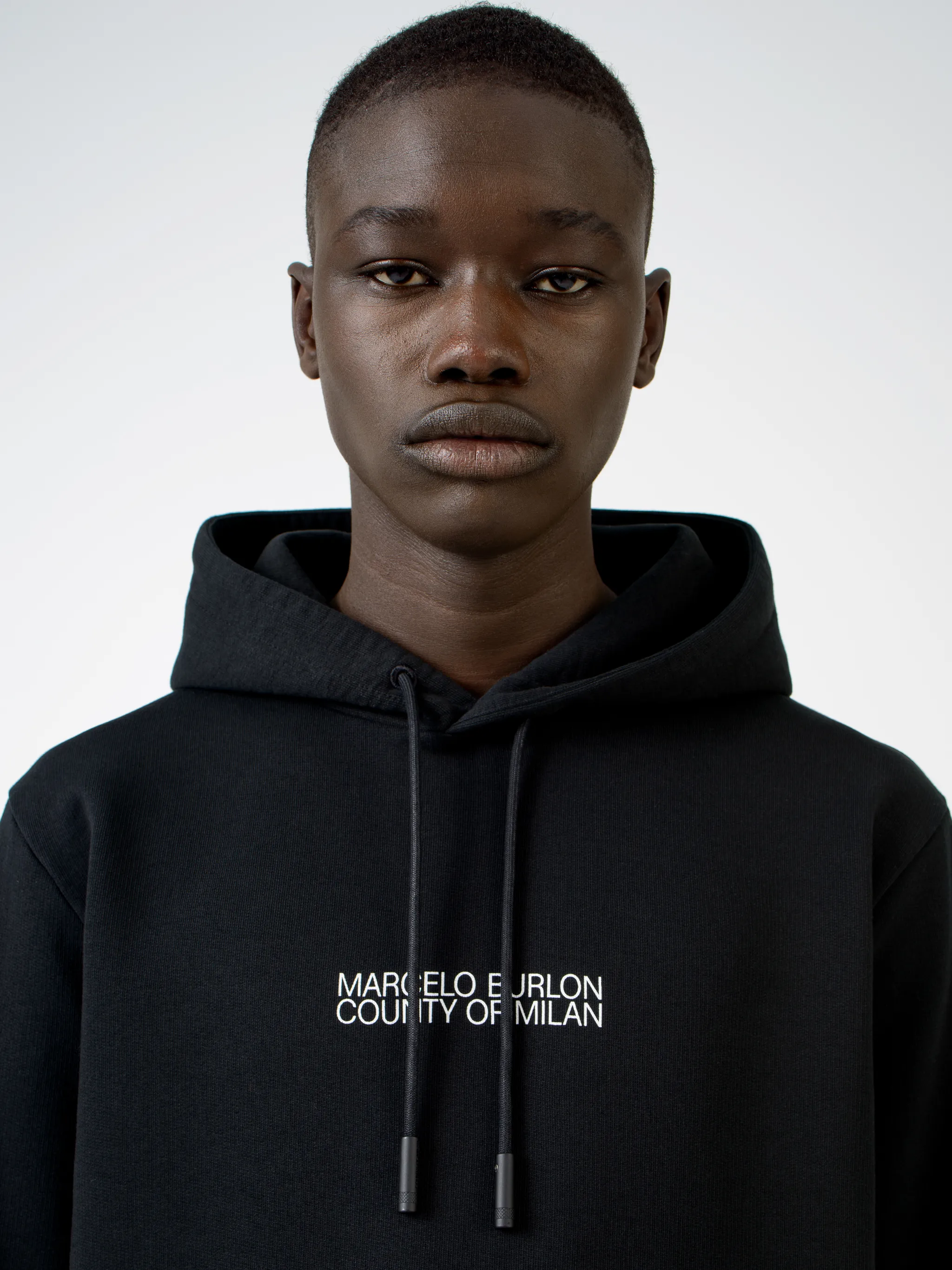 Black cotton logo print hoodie from MARCELO BURLON COUNTY OF MILAN featuring drawstring hood, logo print to the front, long sleeves, abstract pattern print, kangaroo pocket and loose fit.