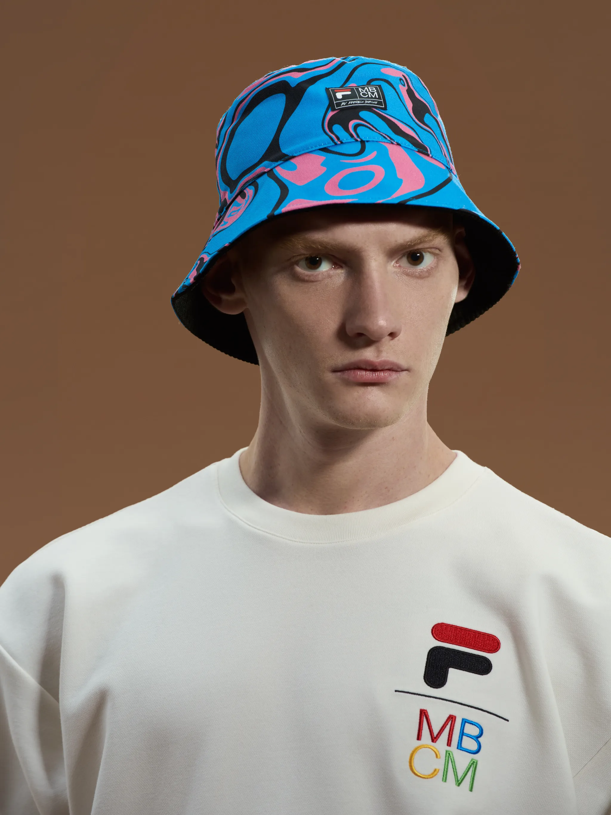 Black/multicolour cotton x Fila psychedelic bucket hat from Marcelo Burlon County of Milan featuring all-over graphic print, reversible, logo patch to the front and dropped narrow brim.