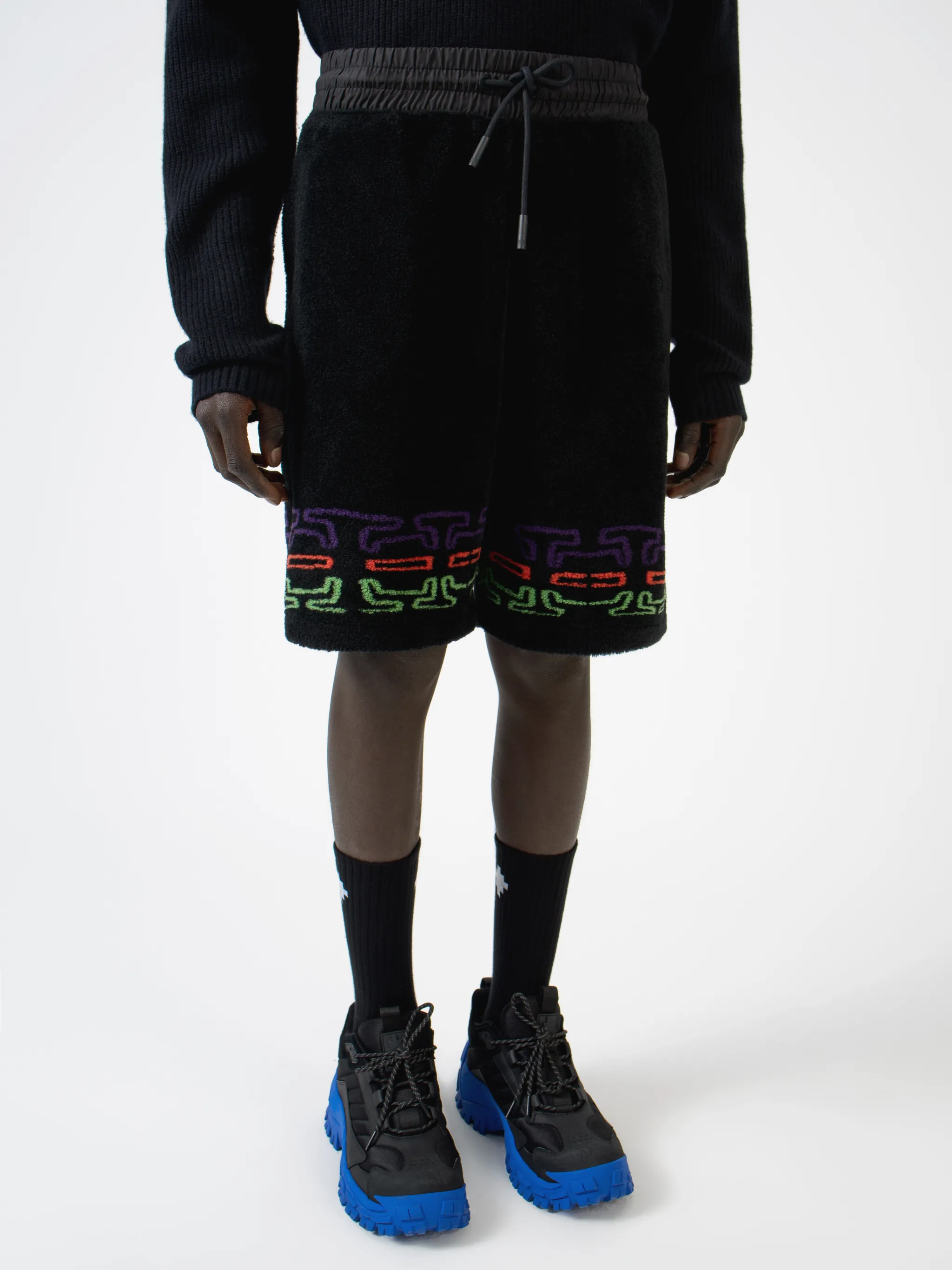 Black/multicolour logo print fleece track shorts from Marcelo Burlon County of Milan featuring jersey fleece, logo print embellishment, elasticated waistband, drawstring fastening, two side pouch pockets and rear welt pocket.