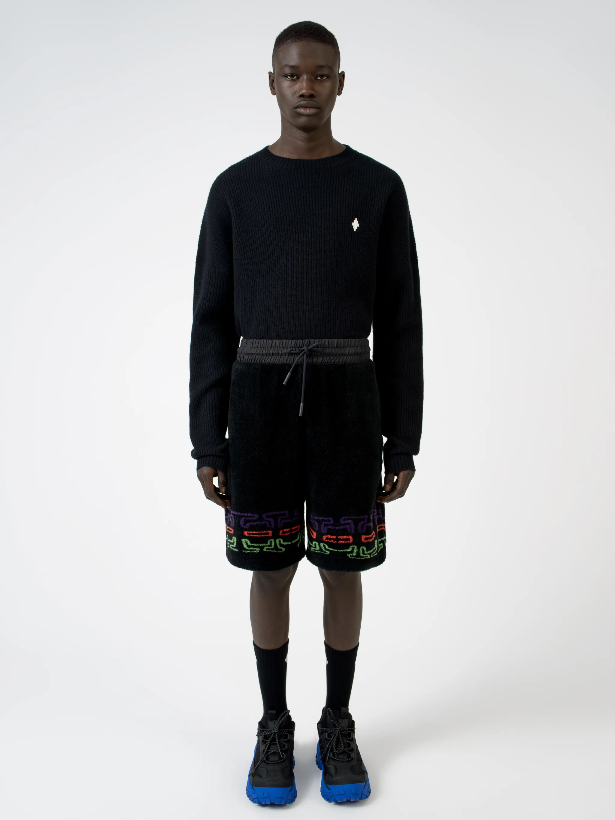 Black/multicolour logo print fleece track shorts from Marcelo Burlon County of Milan featuring jersey fleece, logo print embellishment, elasticated waistband, drawstring fastening, two side pouch pockets and rear welt pocket.