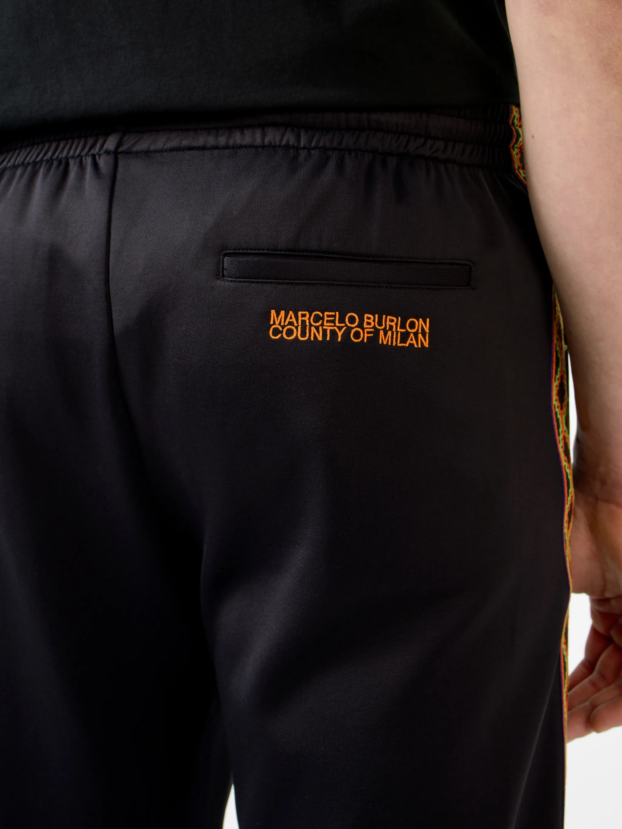 Black/orange/beige cotton-blend Folk tape panel track pants from Marcelo Burlon County of Milan featuring logo-tape detailing, elasticated waistband, two side patch pockets, rear patch pocket, embroidered logo to the rear and straight leg.