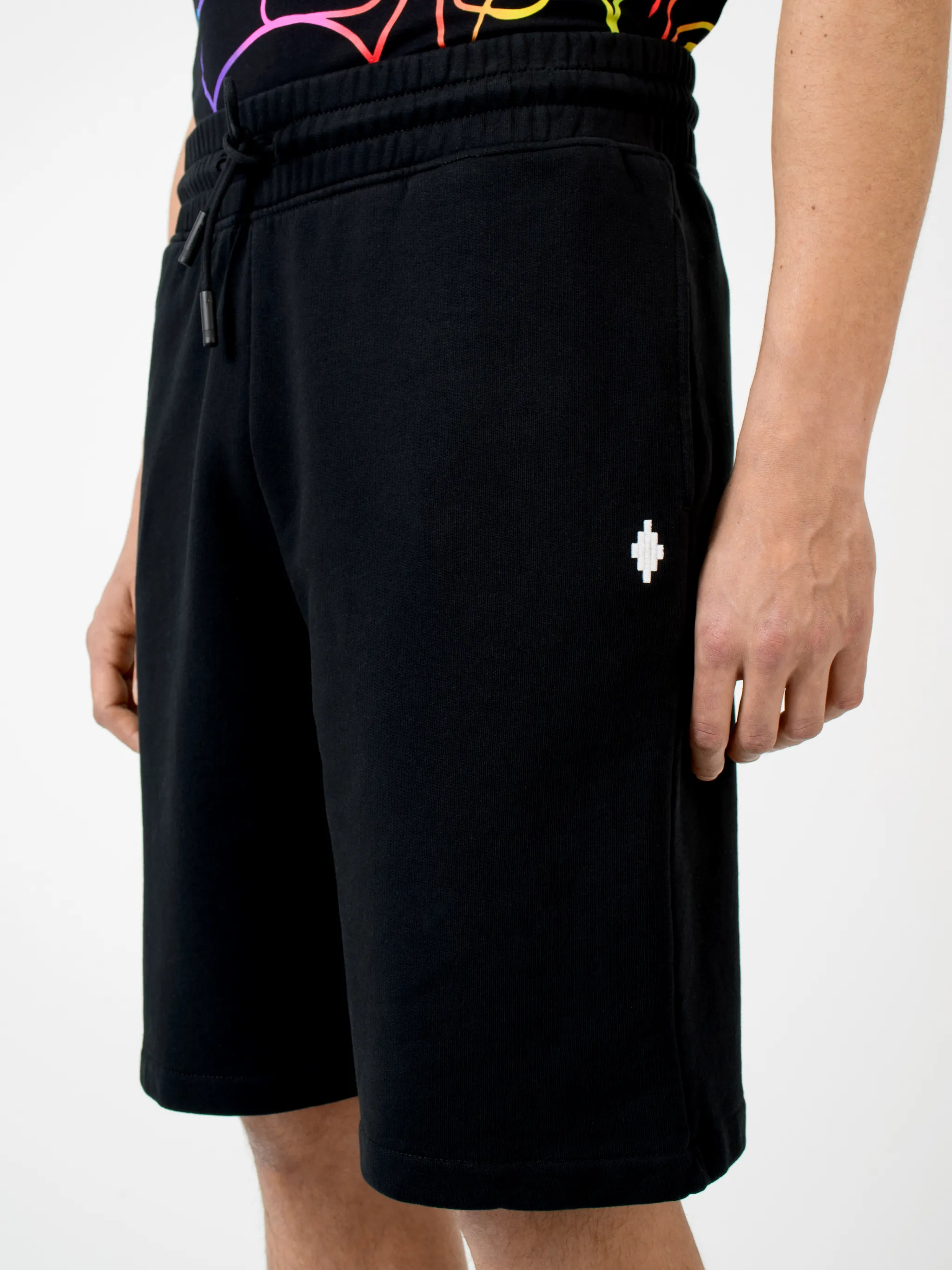 Black cotton printed Illustrated track shorts from Marcelo Burlon County of Milan featuring logo print to the rear, elasticated waistband, drawstring fastening, two side patch pockets, embroidered logo, rear pouch pocket and tonal stitching.