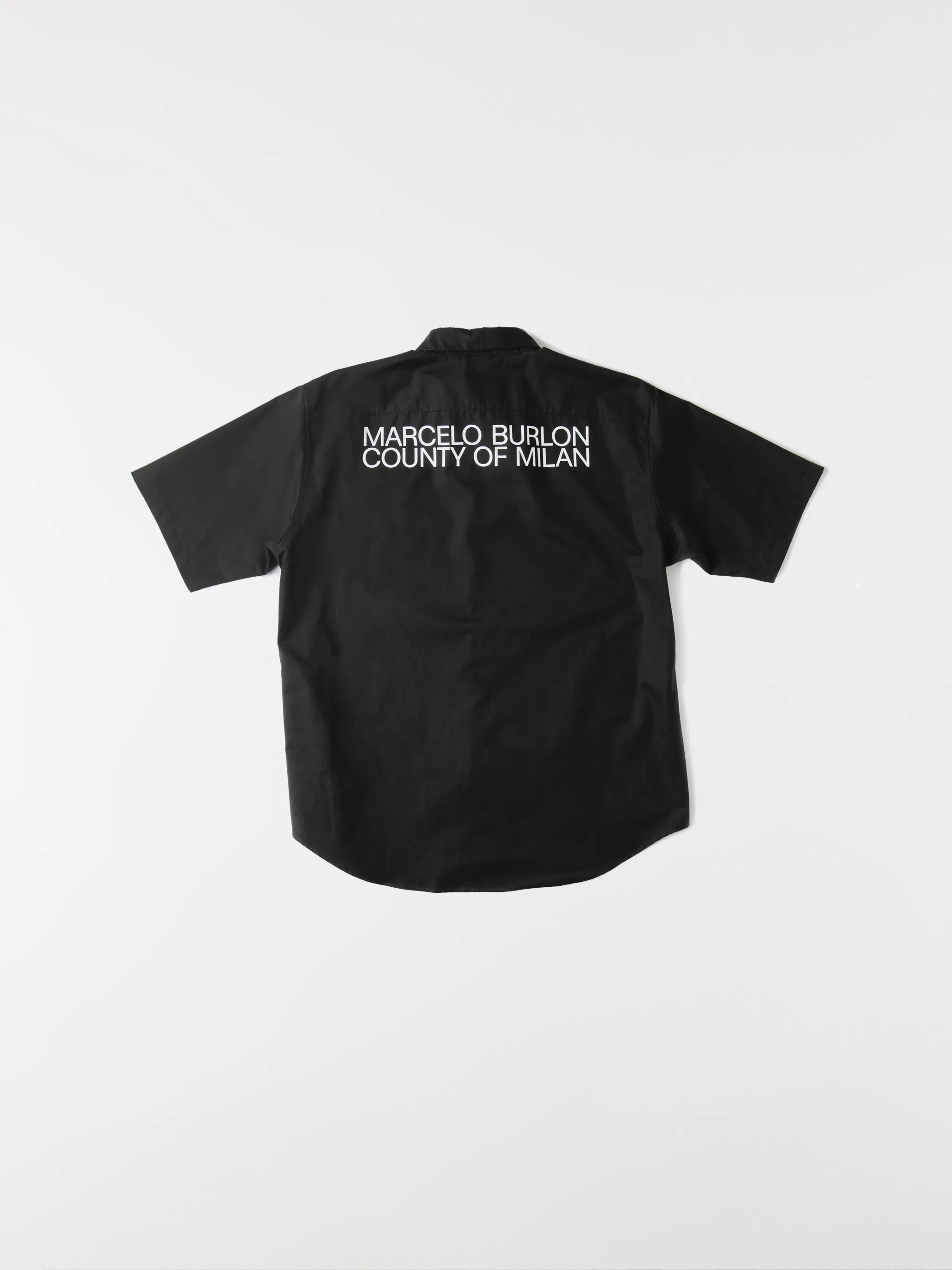 Black cotton logo-print short-sleeve shirt from Marcelo Burlon County of Milan featuring logo print to the rear, logo patches to the front, classic collar, front button fastening, short sleeves, chest patch pocket and curved hem.