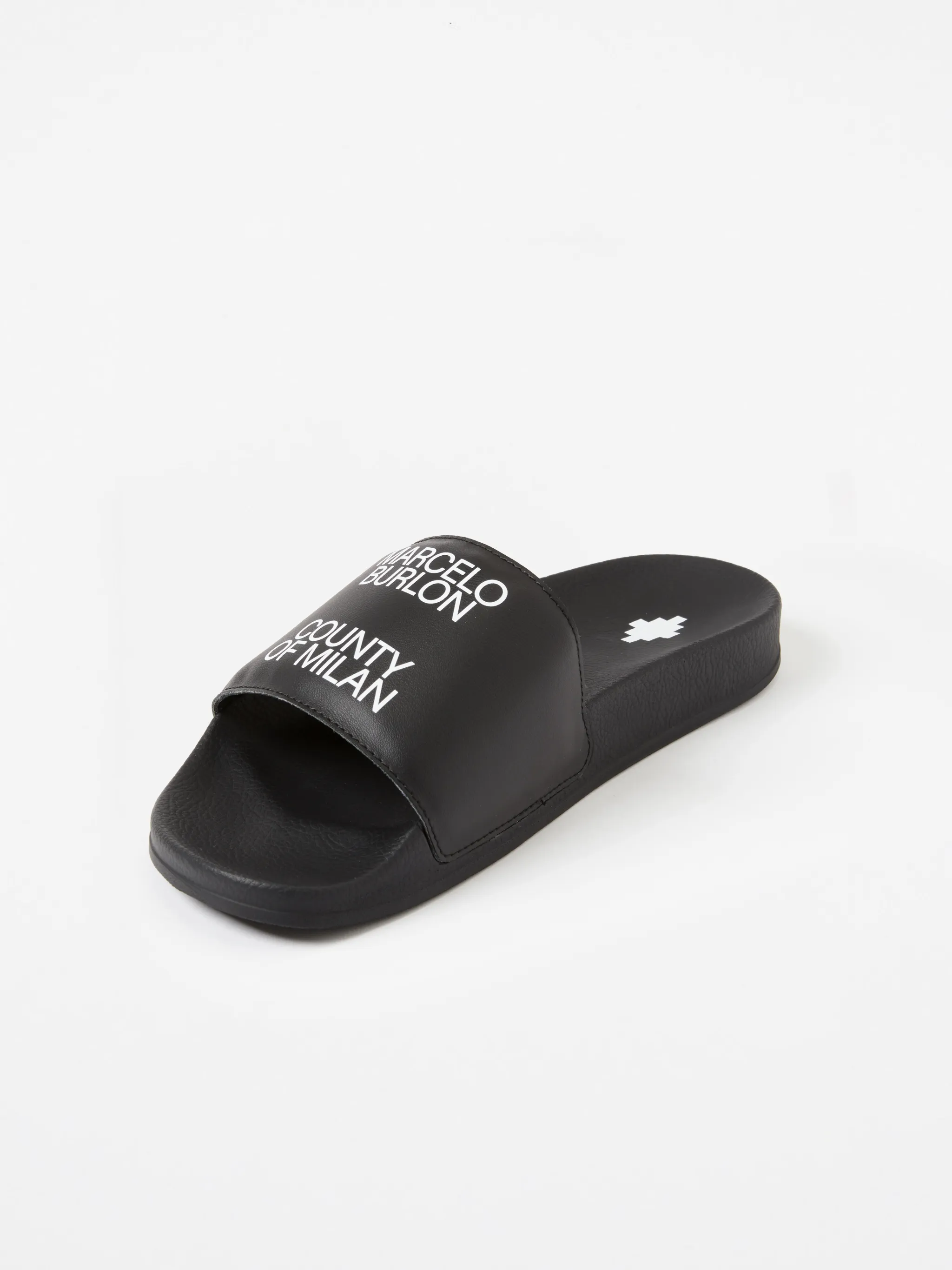 Black/white leather logo sliders from Marcelo Burlon County of Milan featuring slip-on style and all-over logo print.