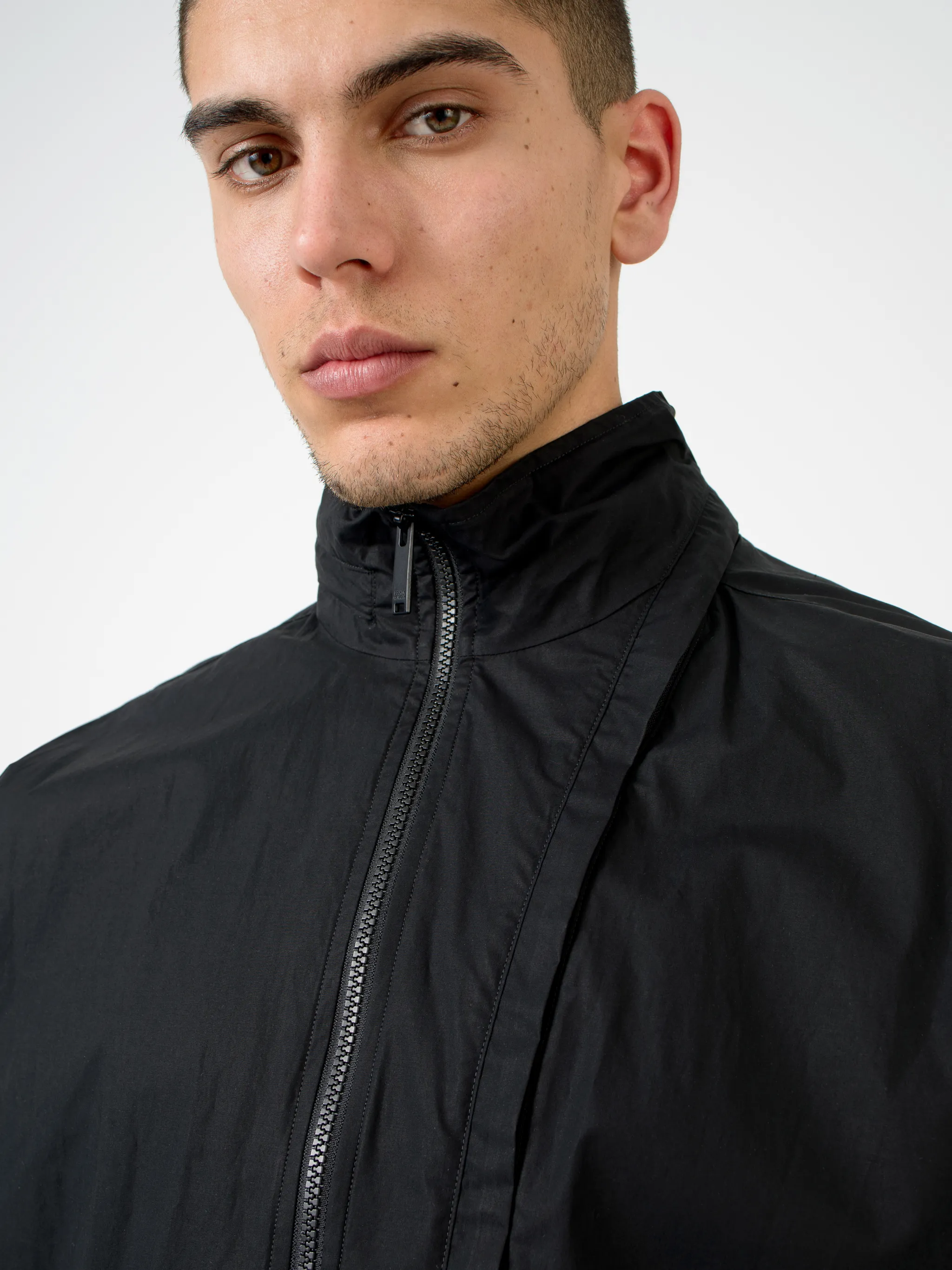 Black cotton-blend logo-print zip-up track jacket from Marcelo Burlon County of Milan featuring logo print to the rear, concealed hood, high neck, front zip fastening, long sleeves, elasticated cuffs and elasticated hem.