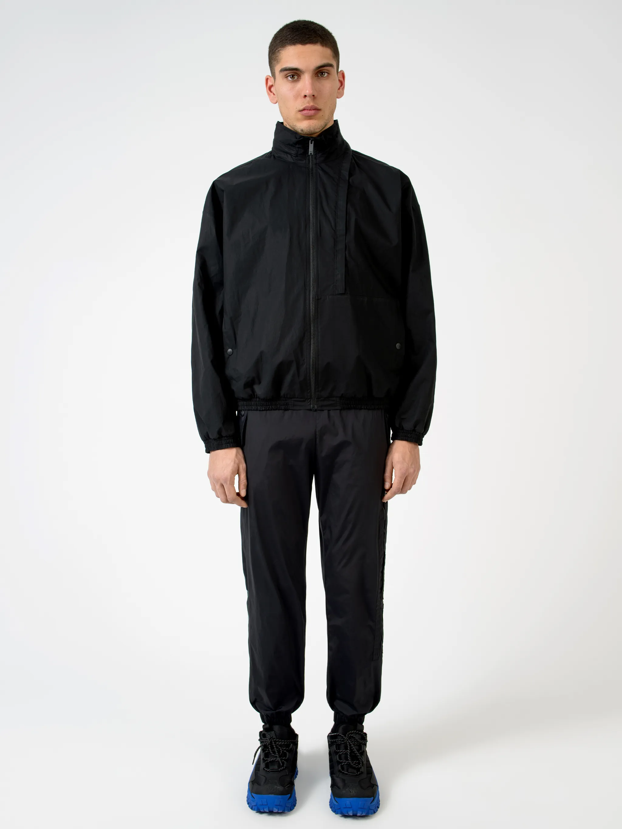 Black cotton-blend logo-print zip-up track jacket from Marcelo Burlon County of Milan featuring logo print to the rear, concealed hood, high neck, front zip fastening, long sleeves, elasticated cuffs and elasticated hem.